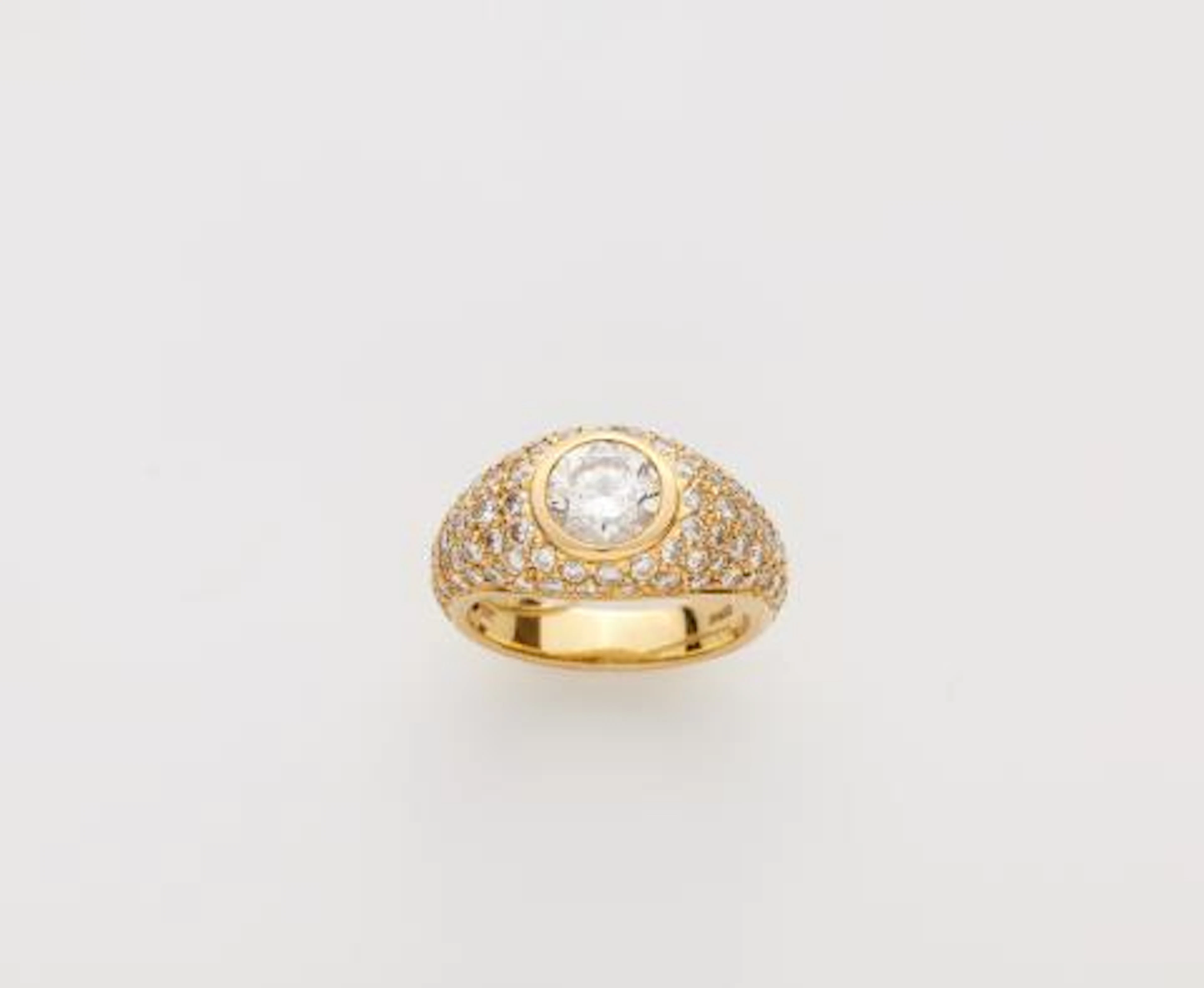 An 18k gold diamond pavé eternity ring with a brilliant-cut diamond solitaire.