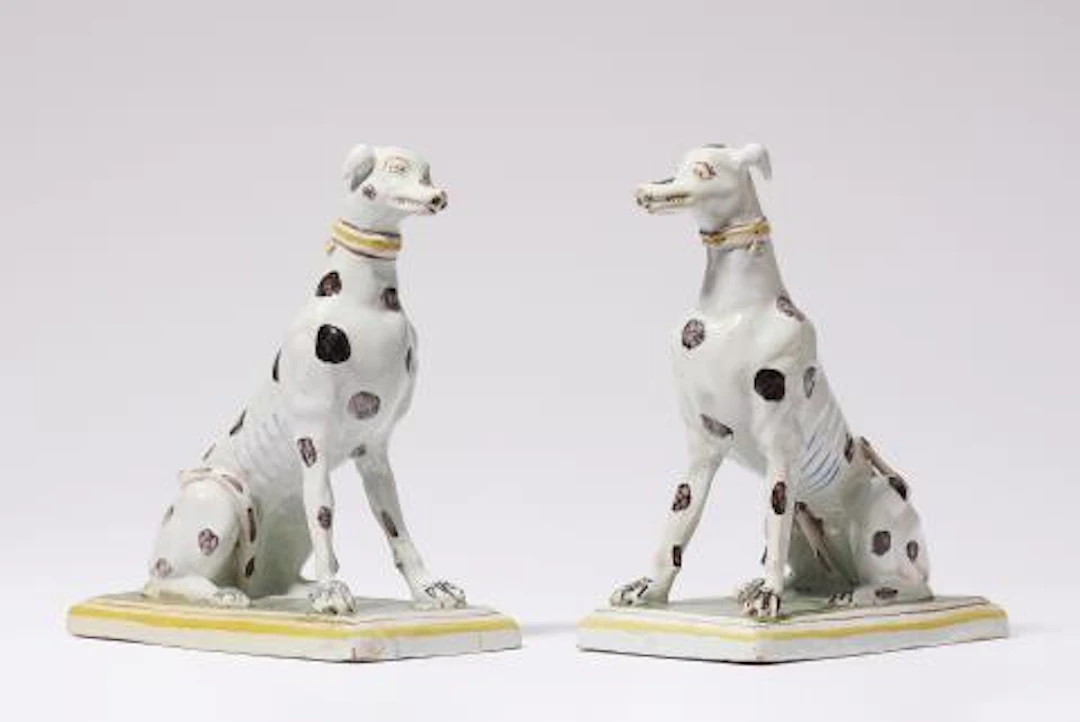 Two faience figures of seated greyhounds