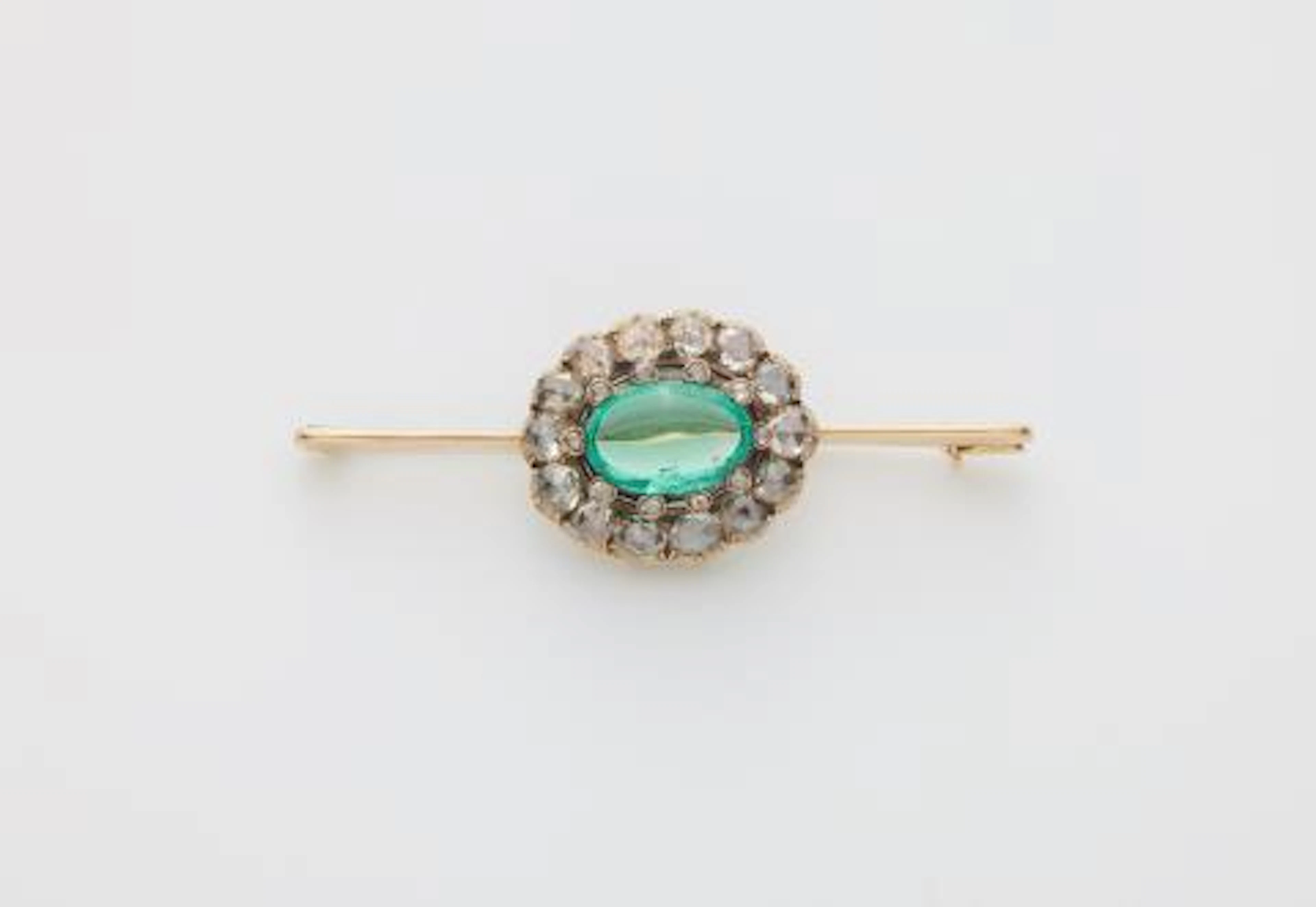 A 14k gold bar brooch with a 19th century rose-cut diamond and emerald