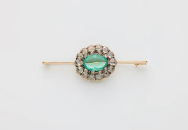 A 14k gold bar brooch with a 19th century rose-cut diamond and emerald