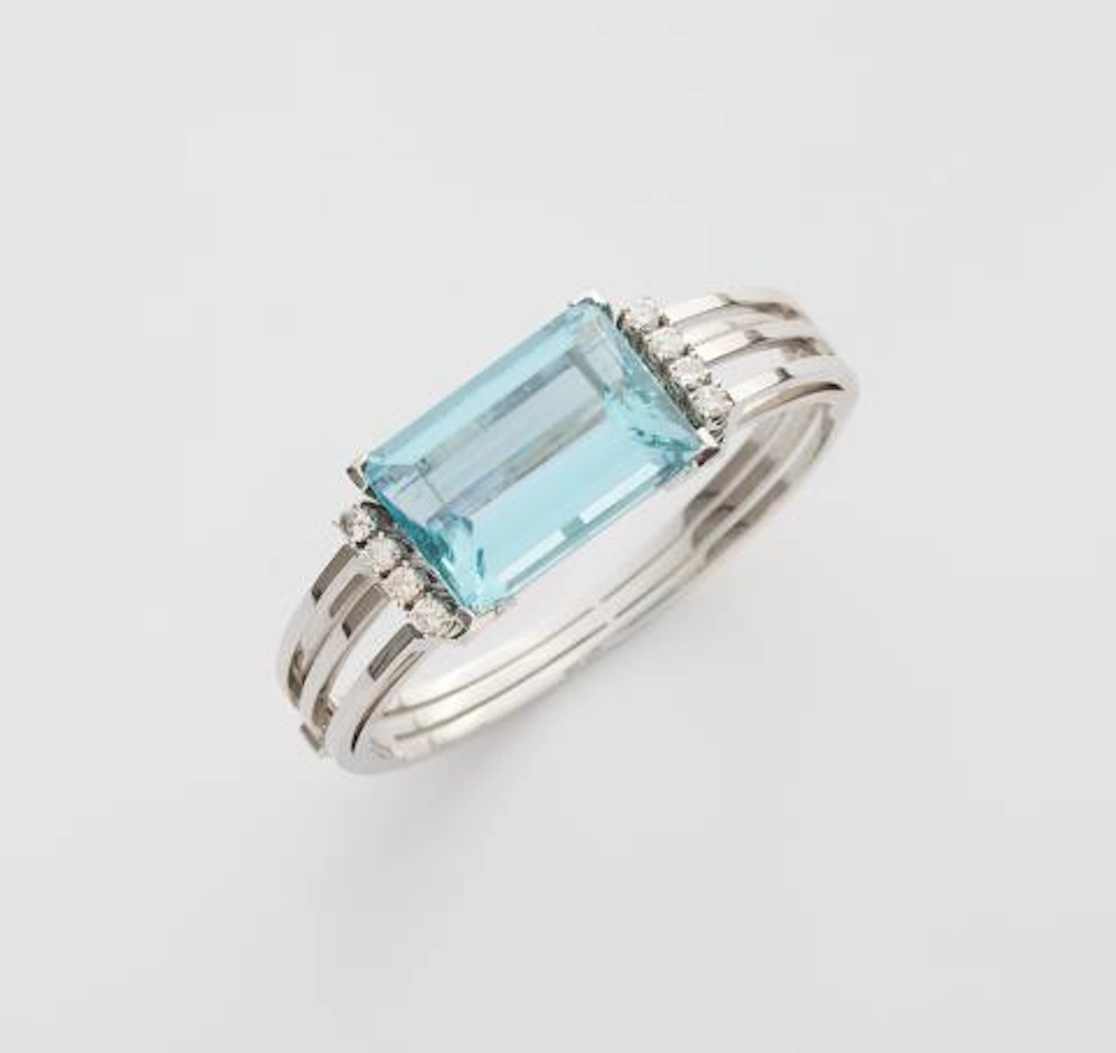 An 18k white gold diamond and large step-cut aquamarine bangle.