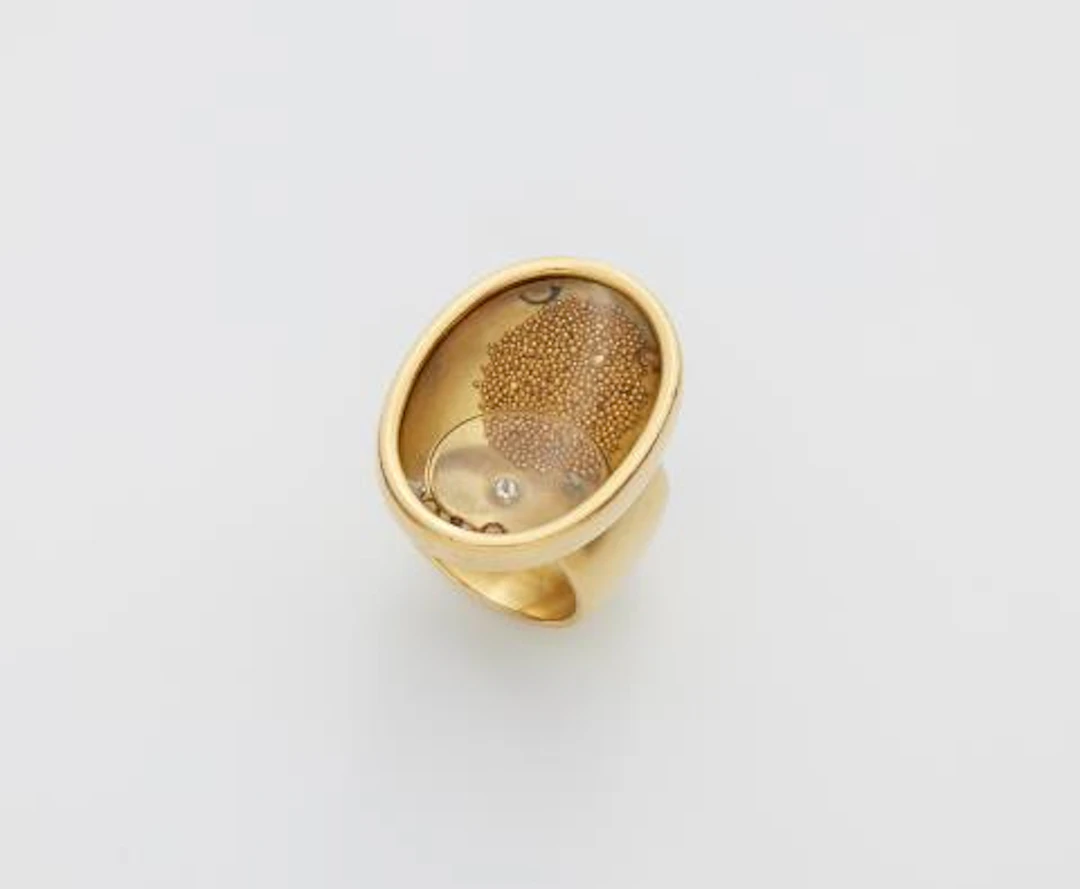 A German 18k gold and rock crystal kinetic capsule ring filled with