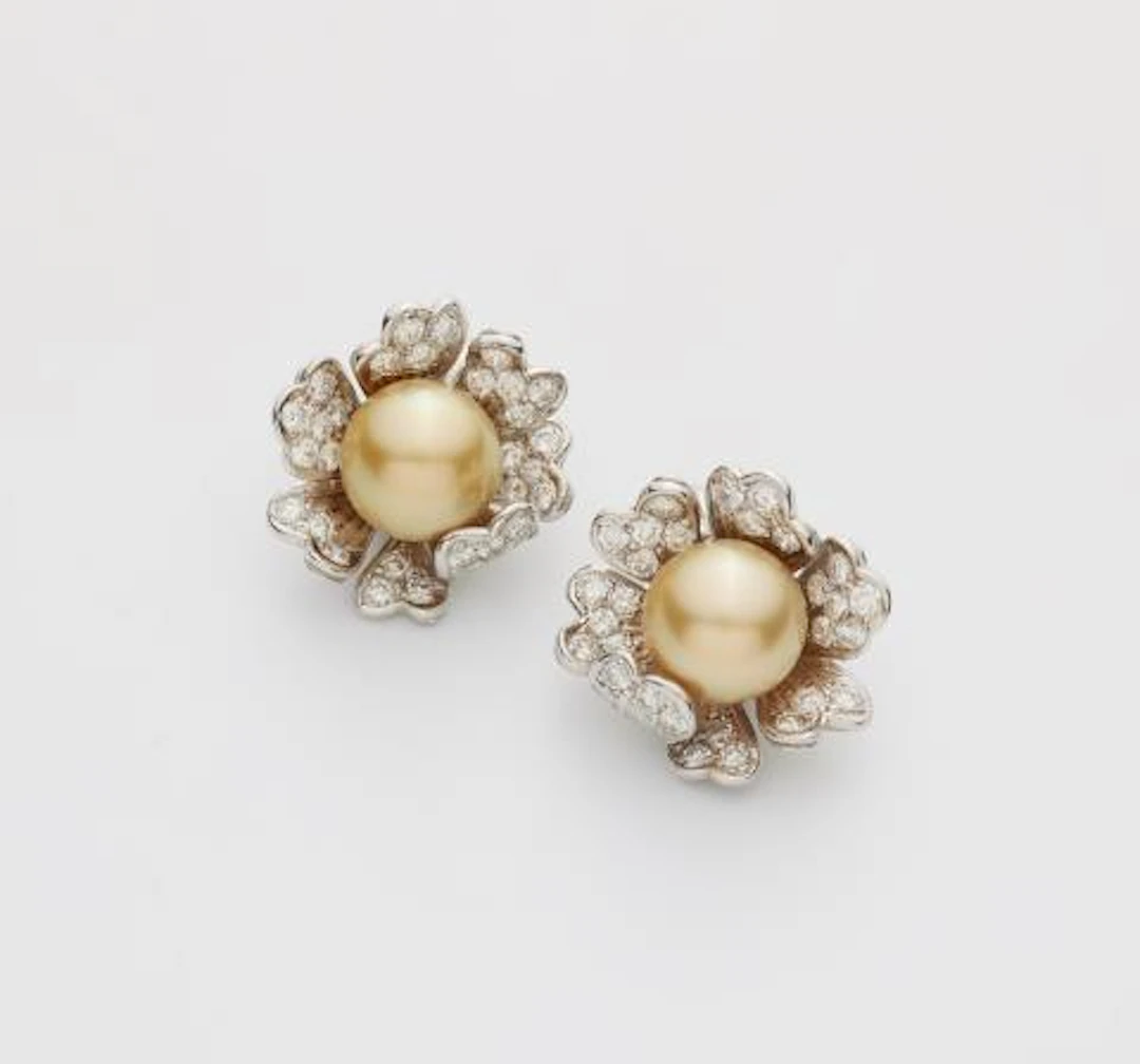 A pair of 18k white gold diamond and golden South Sea pearl clip earrings.