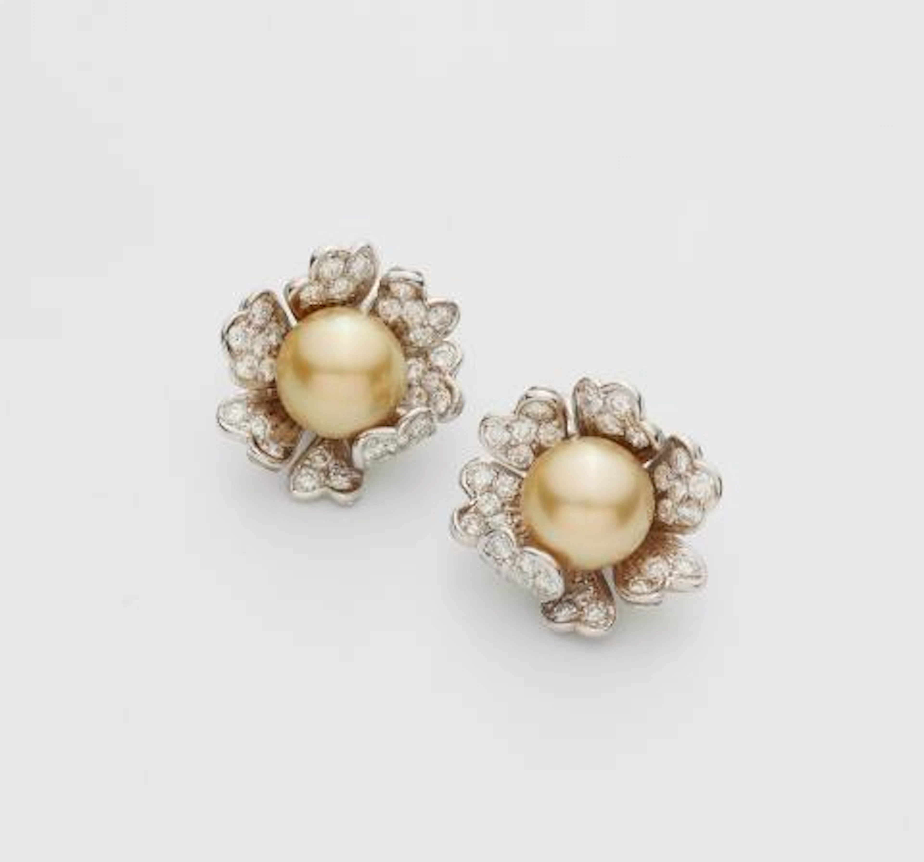 A pair of 18k white gold diamond and golden South Sea pearl clip earrings.