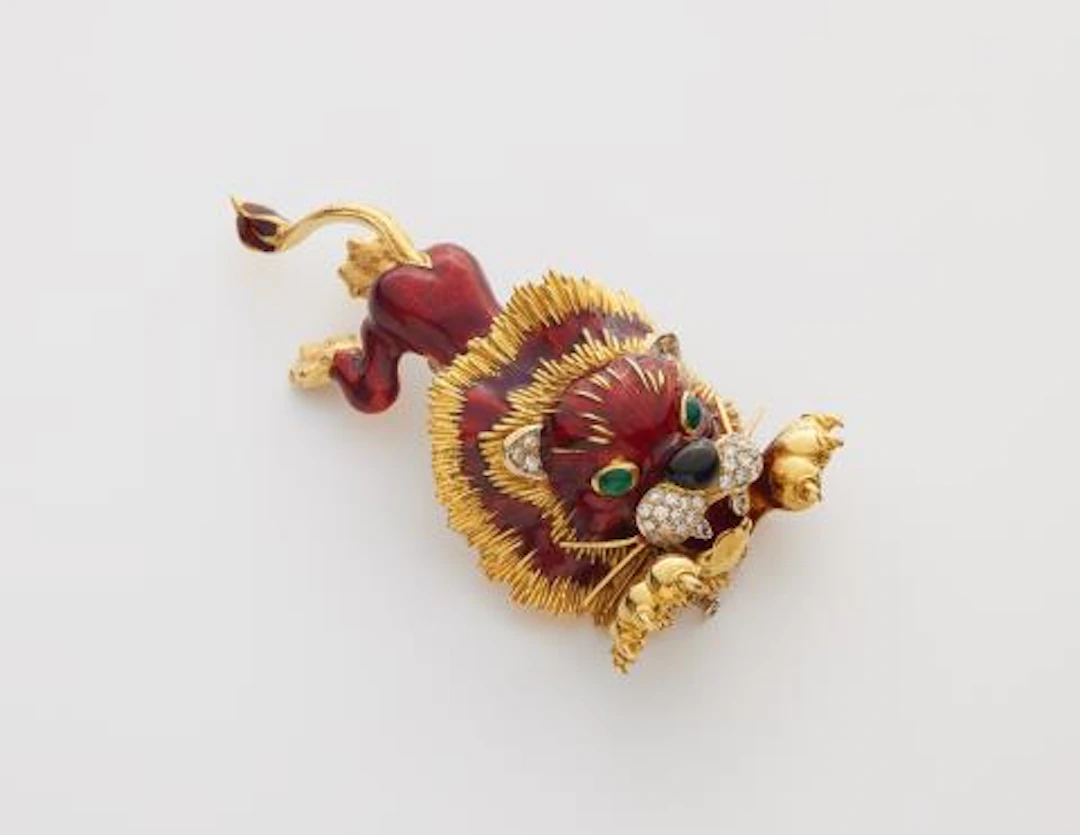 An 18k gold, diamond and enamel lion clip brooch.