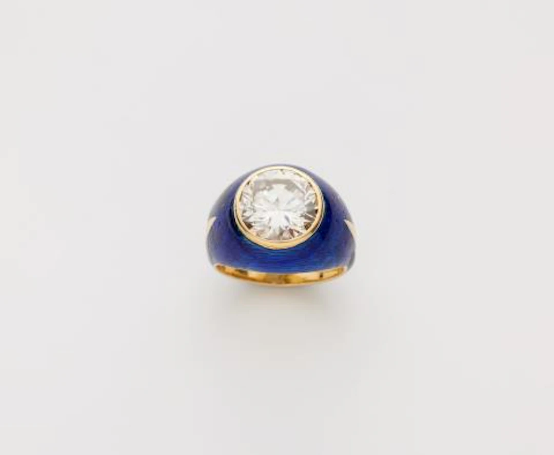 An 18k gold translucent blue enamel and diamond solitaire band ring.
