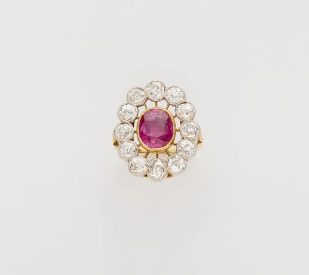 An 18k gold diamond and natural Burma ruby (NTE) cluster ring.