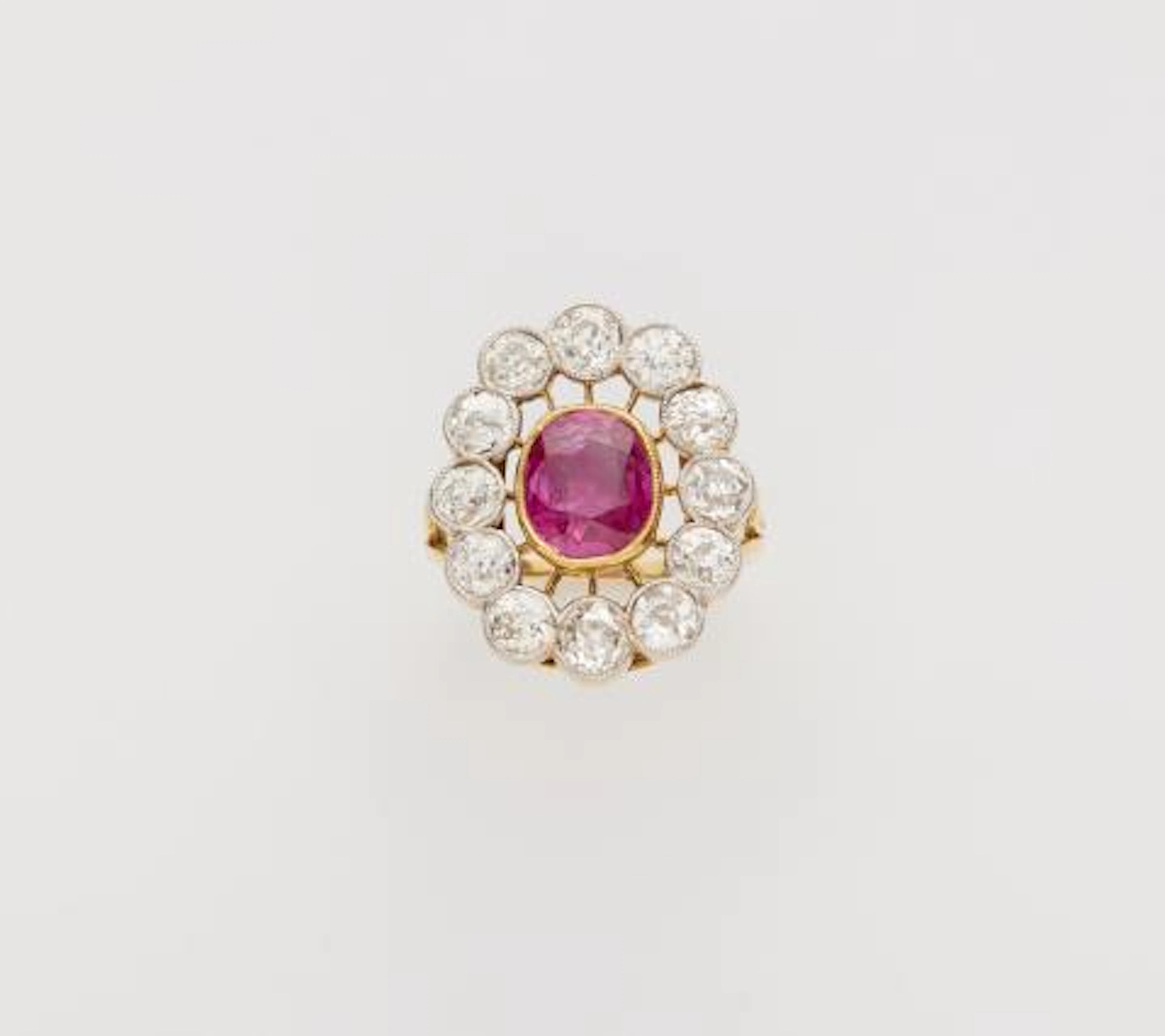 An 18k gold diamond and natural Burma ruby (NTE) cluster ring.