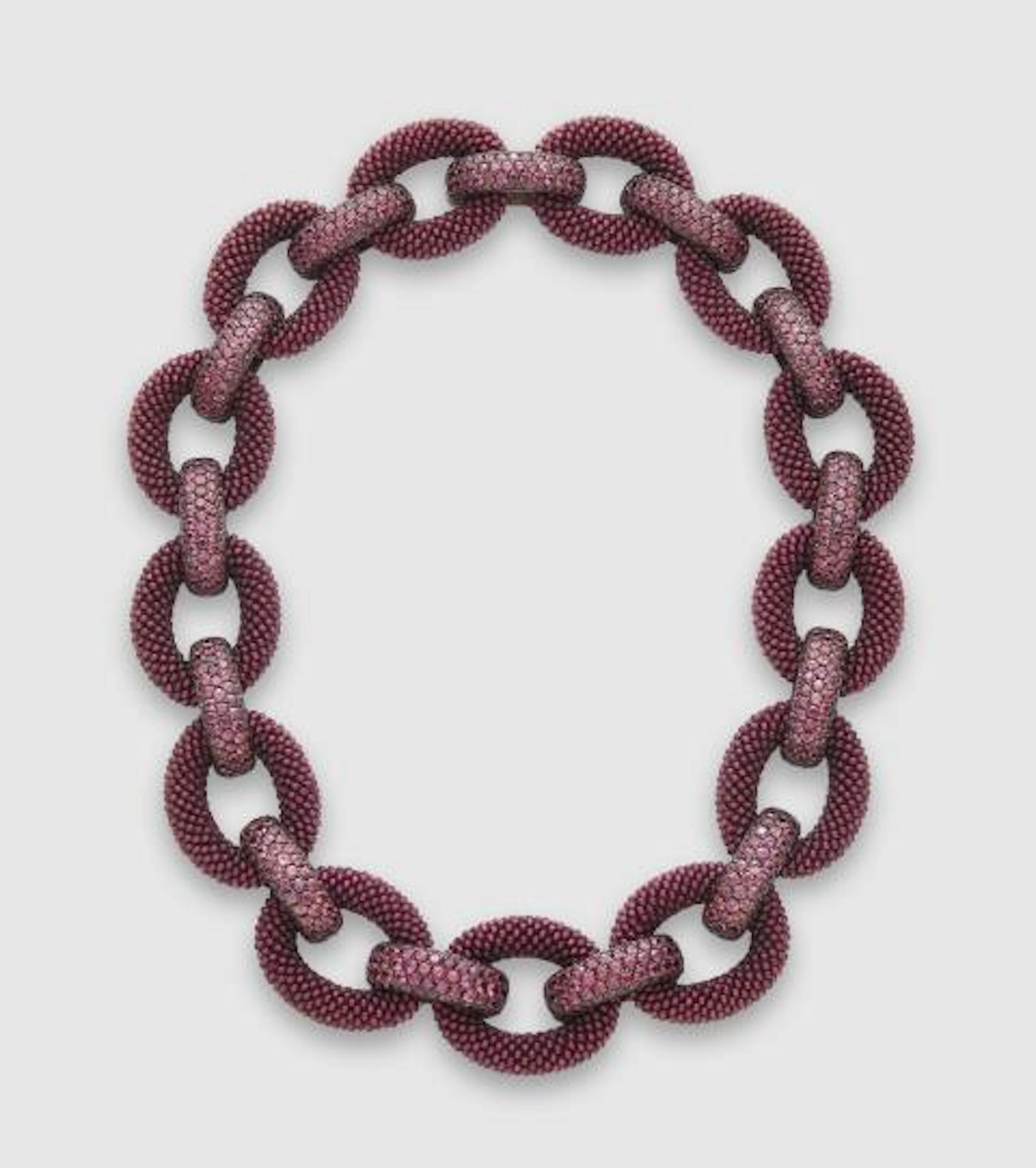 An 18k white gold oxydised silver interwoven garnet and natural burgundy