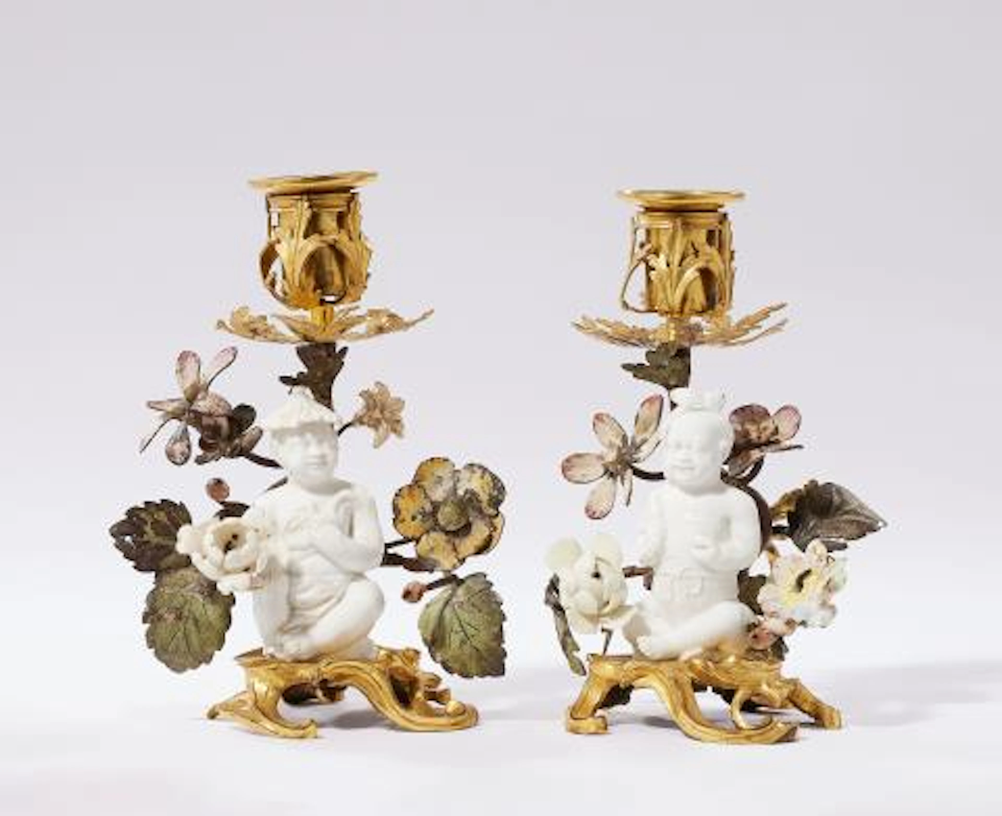 A pair of ormolu chambersticks with figures of children