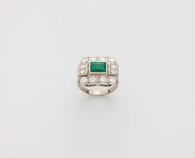 An 18k white gold diamond and fine emerald ring.