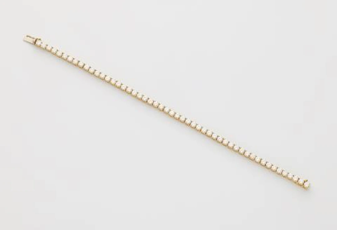 An 18k gold and brilliant-cut diamond line bracelet.