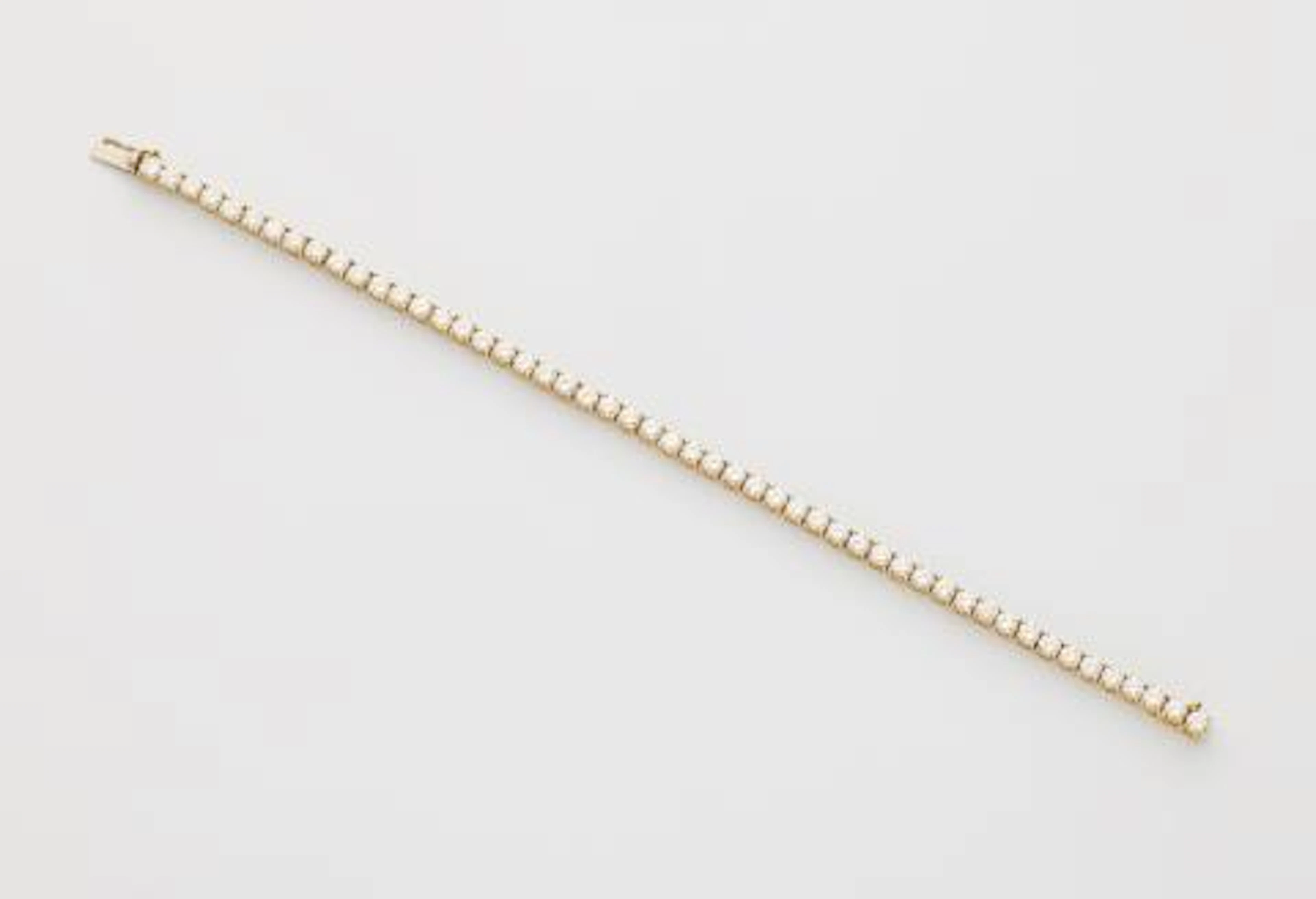 An 18k gold and brilliant-cut diamond line bracelet.