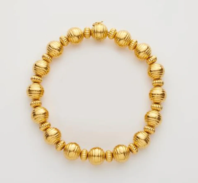 A Greek 18k yellow gold ribbed bead necklace.