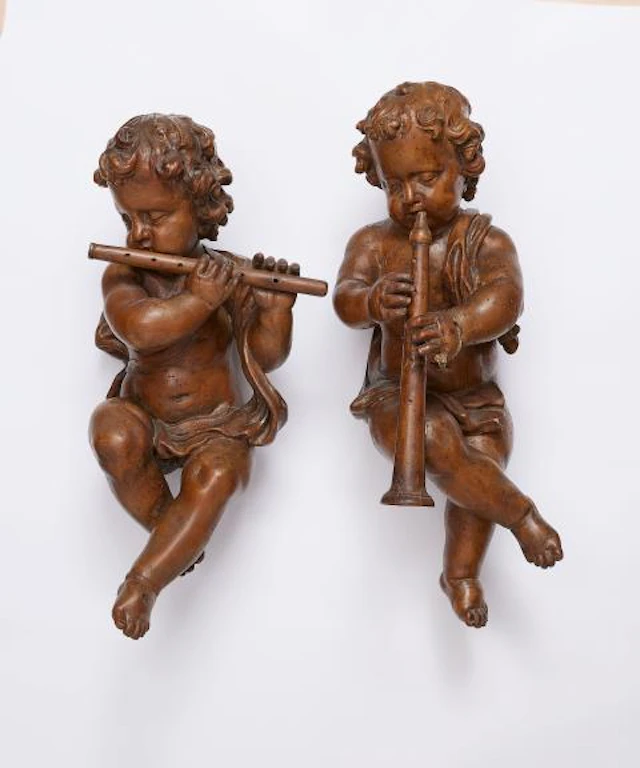 A pair of seated putti making music