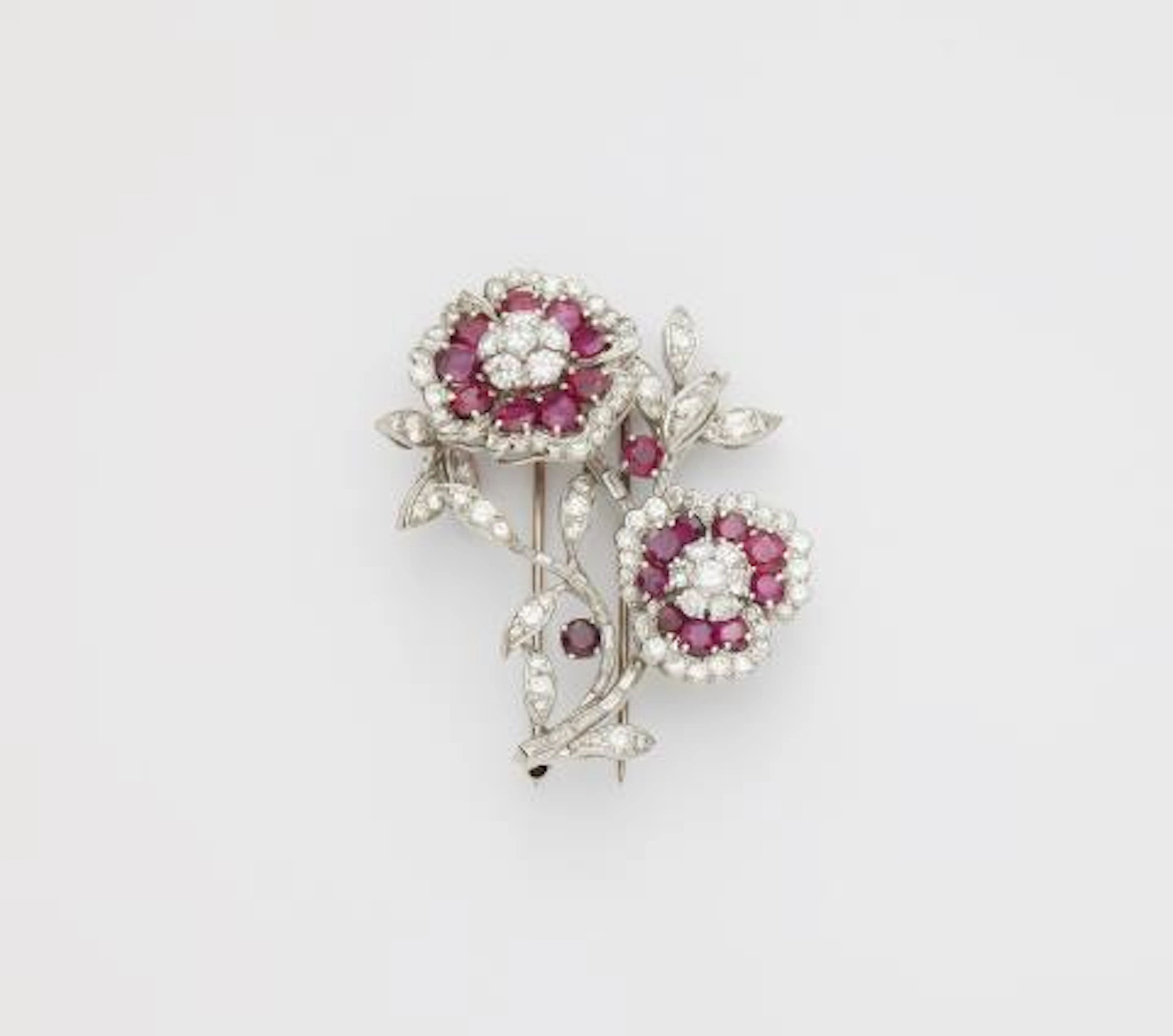 An American platinum 18k gold diamond and ruby rose sprig clip brooch.