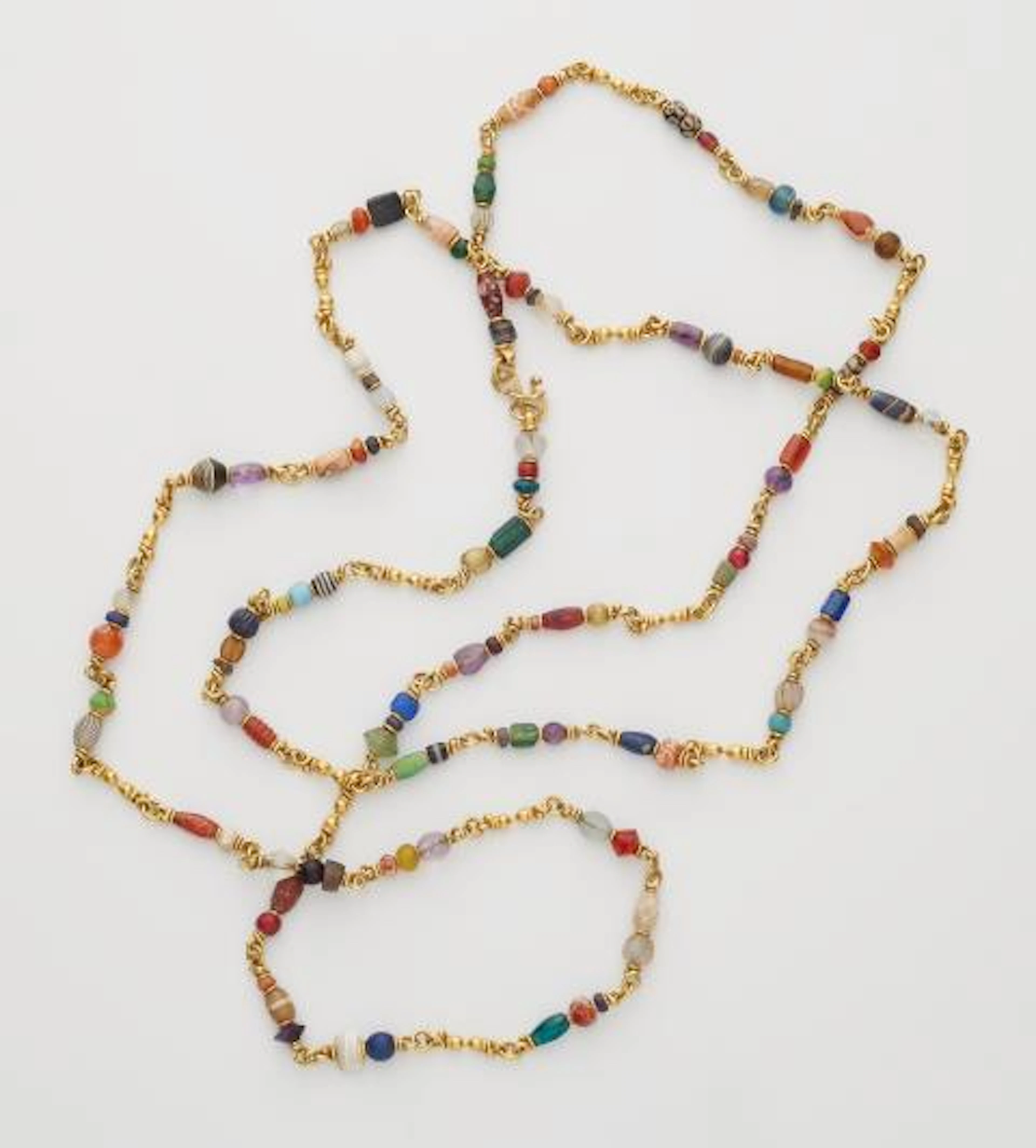 A forged 21.6k yellow gold and polychrome ancient Islamic glass and