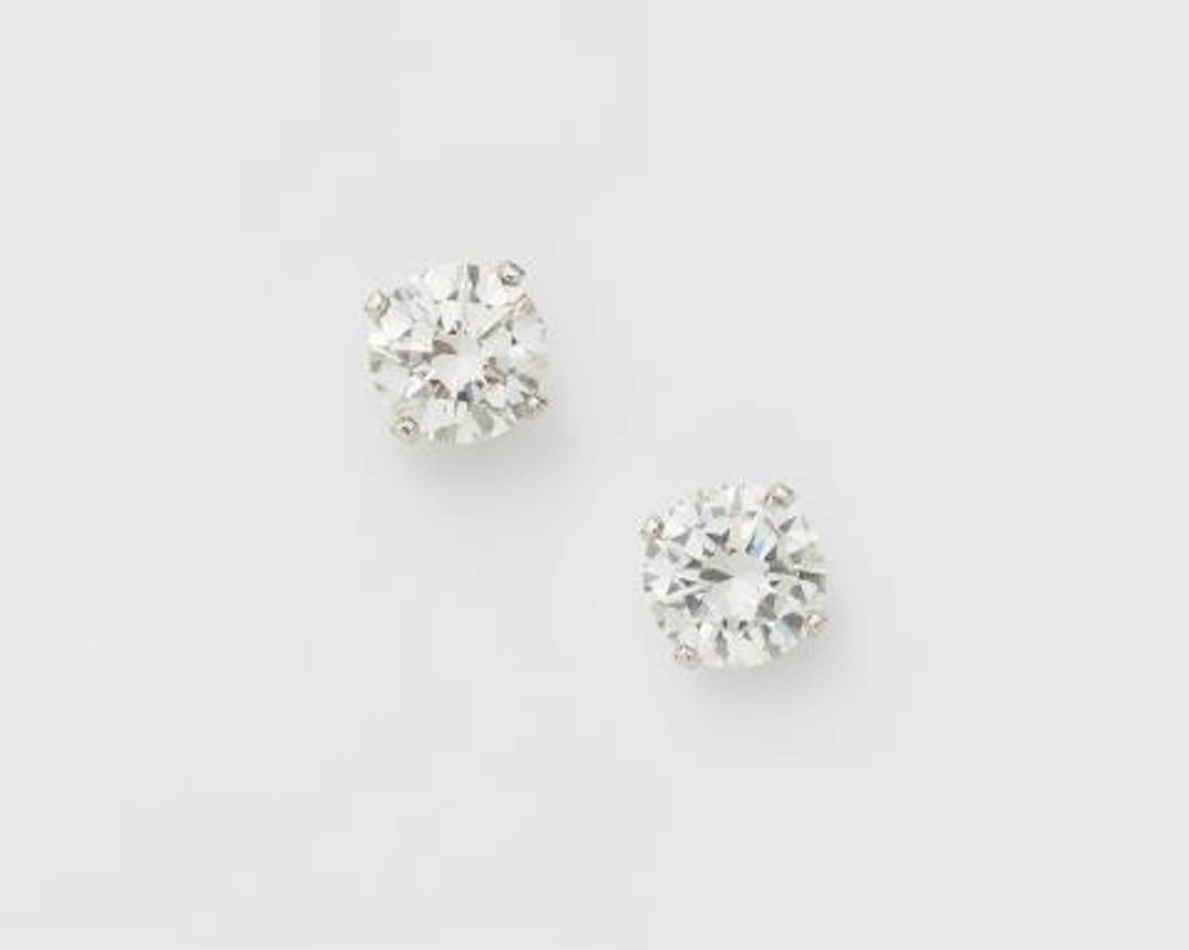 A pair of 18k white gold and brillant-cut diamond solitaire stud earrings.