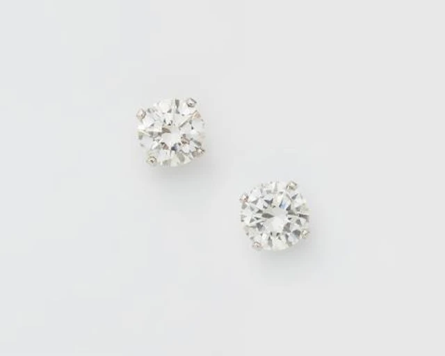 A pair of 18k white gold and brillant-cut diamond solitaire stud earrings.