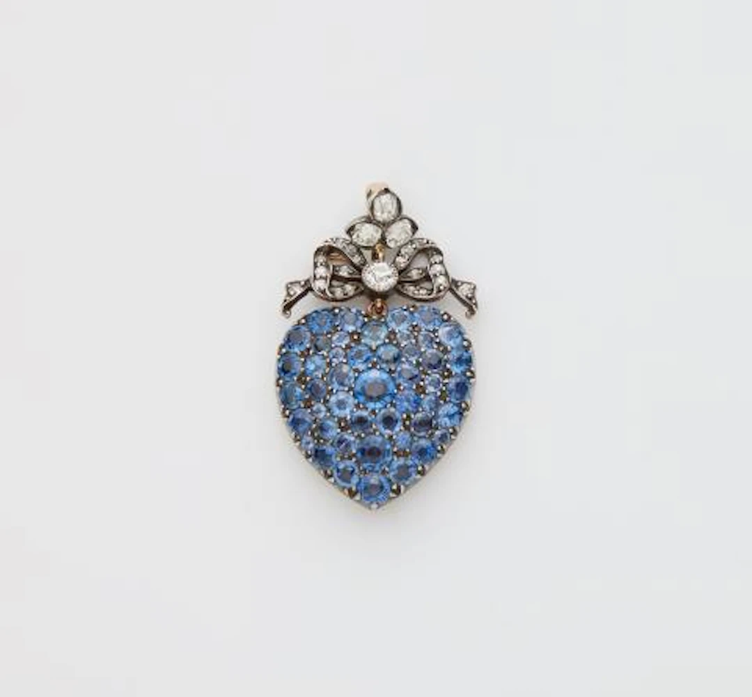 A Victorian silver 14k gold diamond and sapphire heart locket.