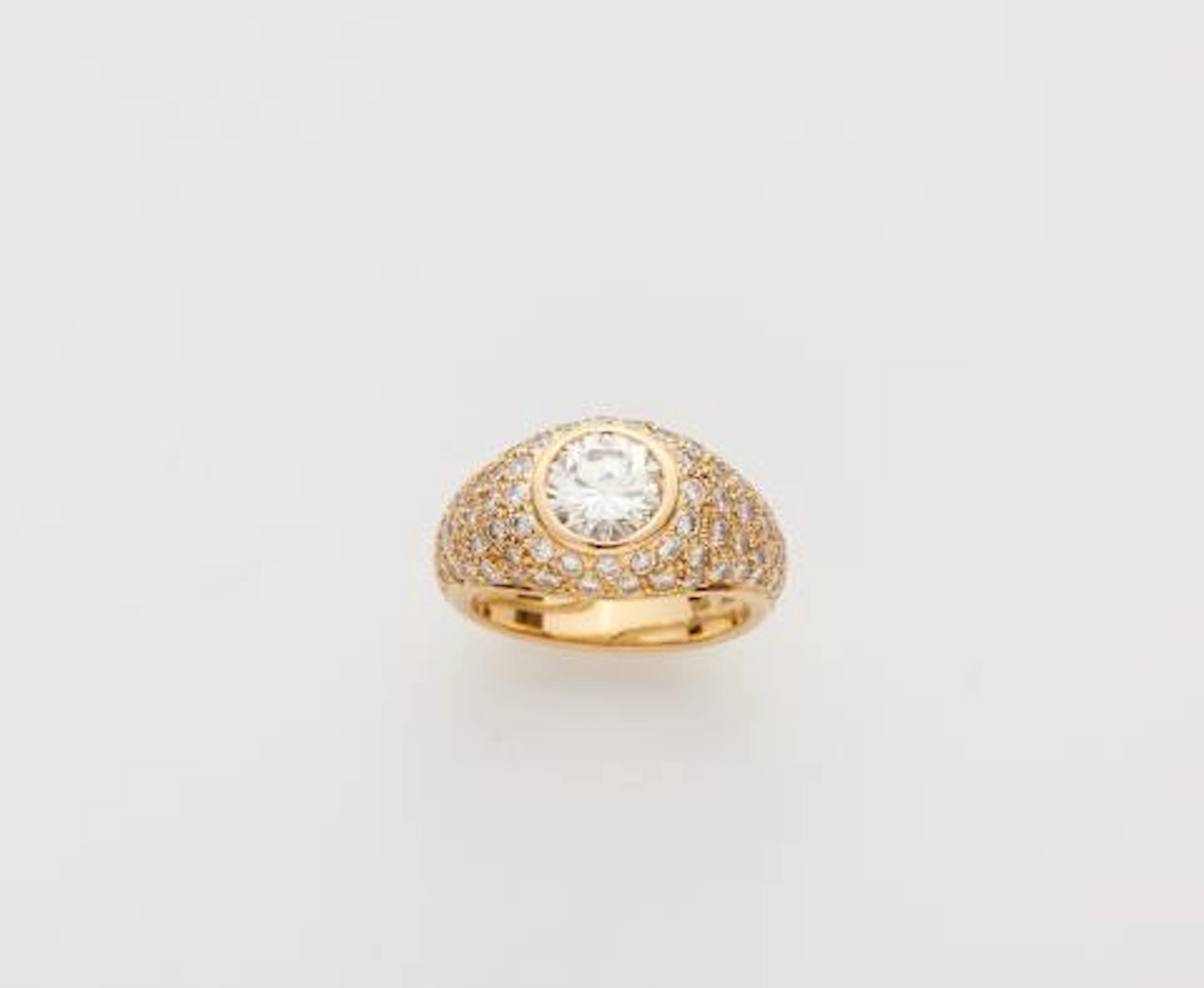 An 18k gold diamond pavé eternity ring with a brilliant-cut diamond solitaire.