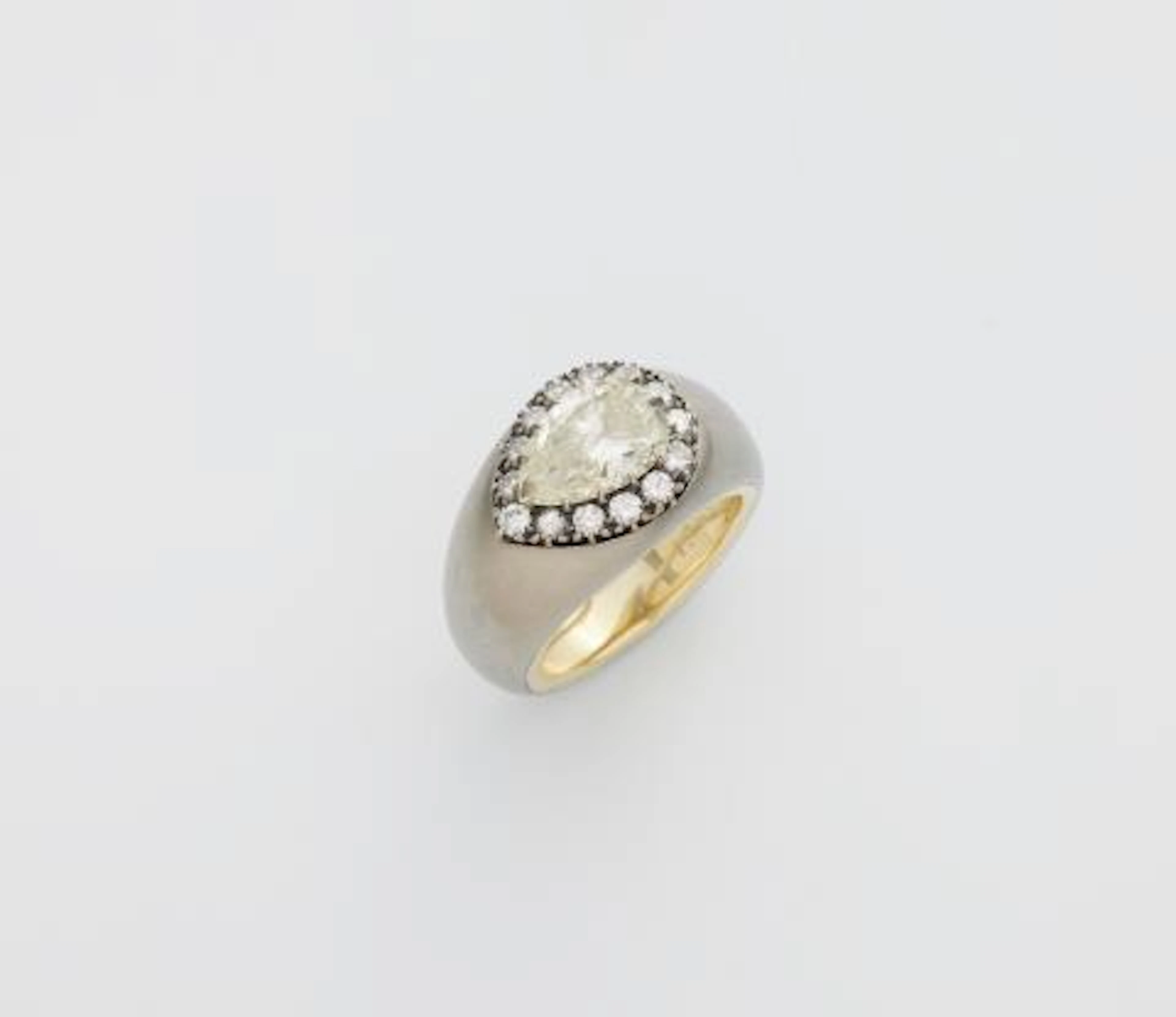 A brushed steel yellow gold and pear-cut diamond solitaire ring.