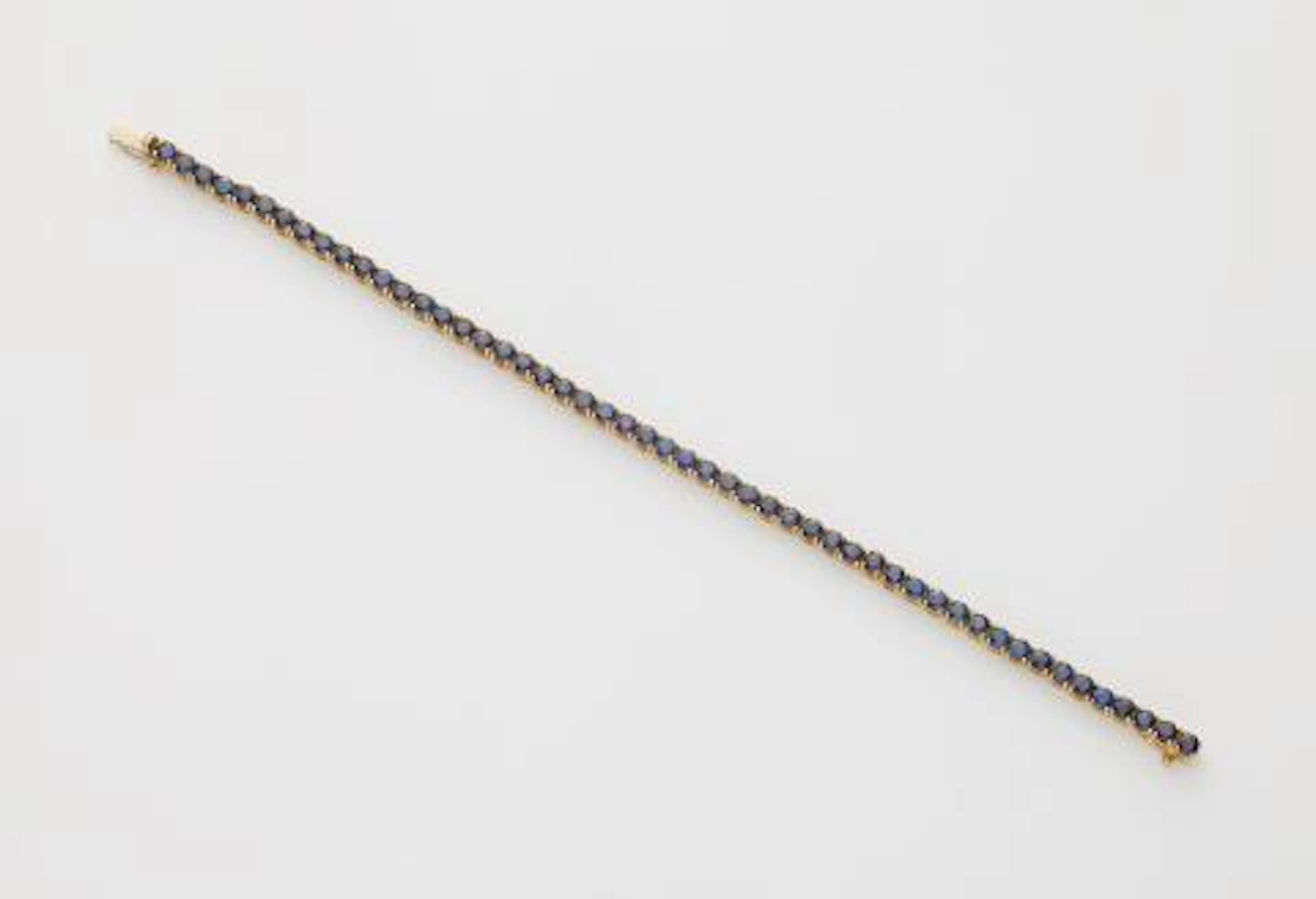 An 18k white gold and sapphire rivière bracelet.