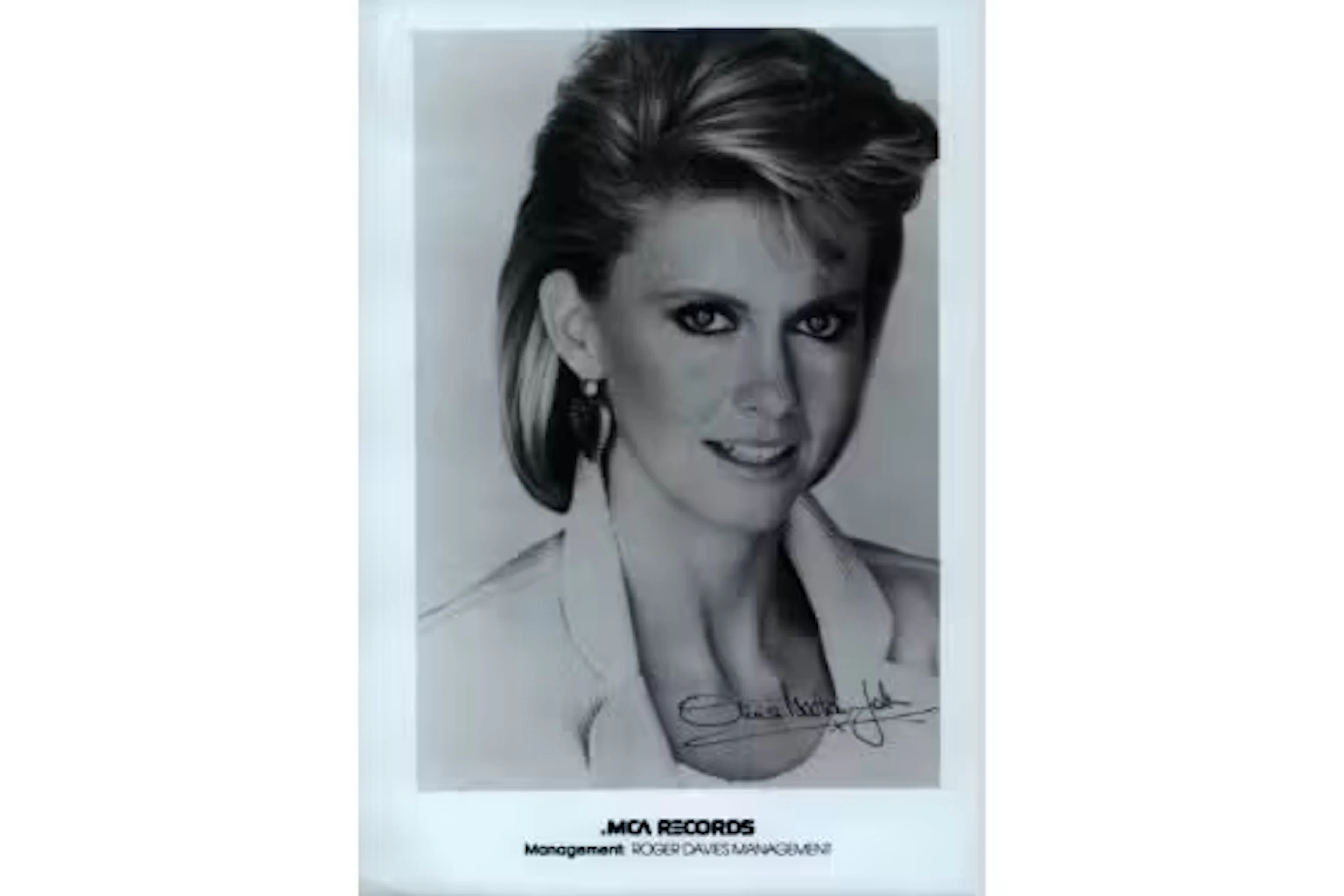 Olivia Newton John printed signature on 7x5inch black and white photo.