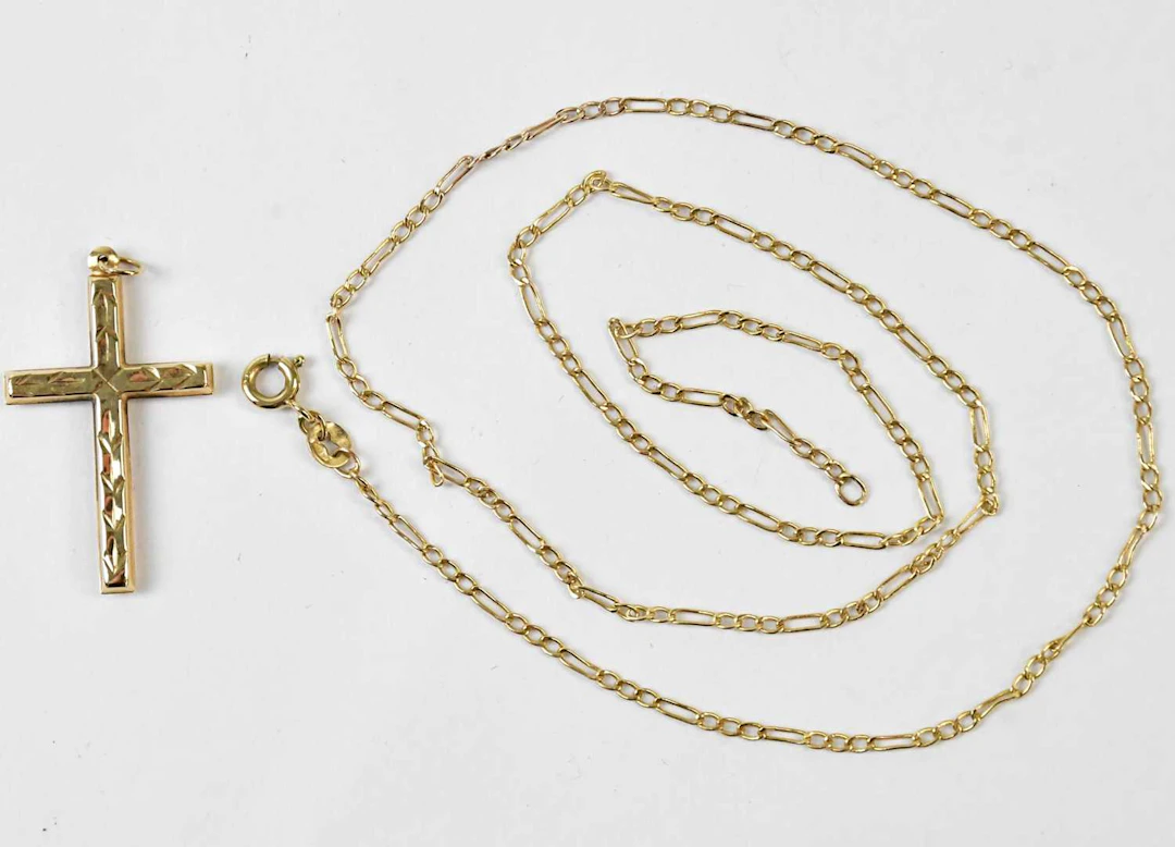 A yellow metal cross pendant
