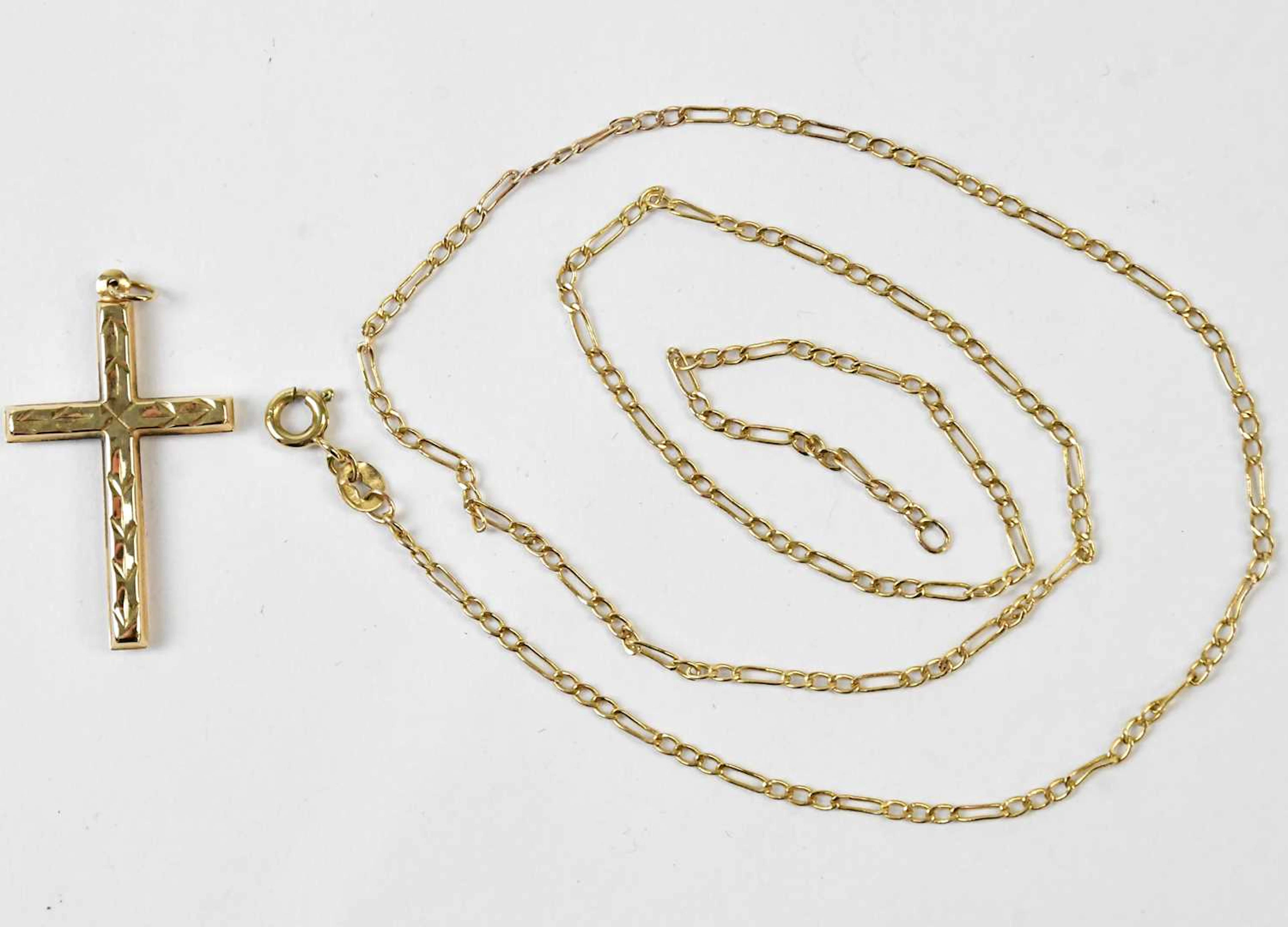 A yellow metal cross pendant