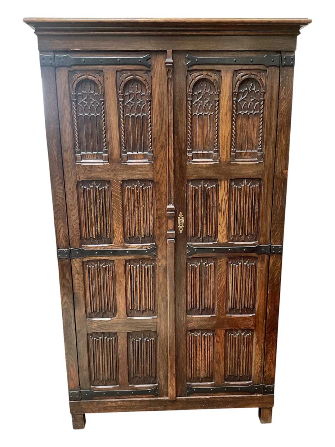 A carved oak Priory style wardrobe