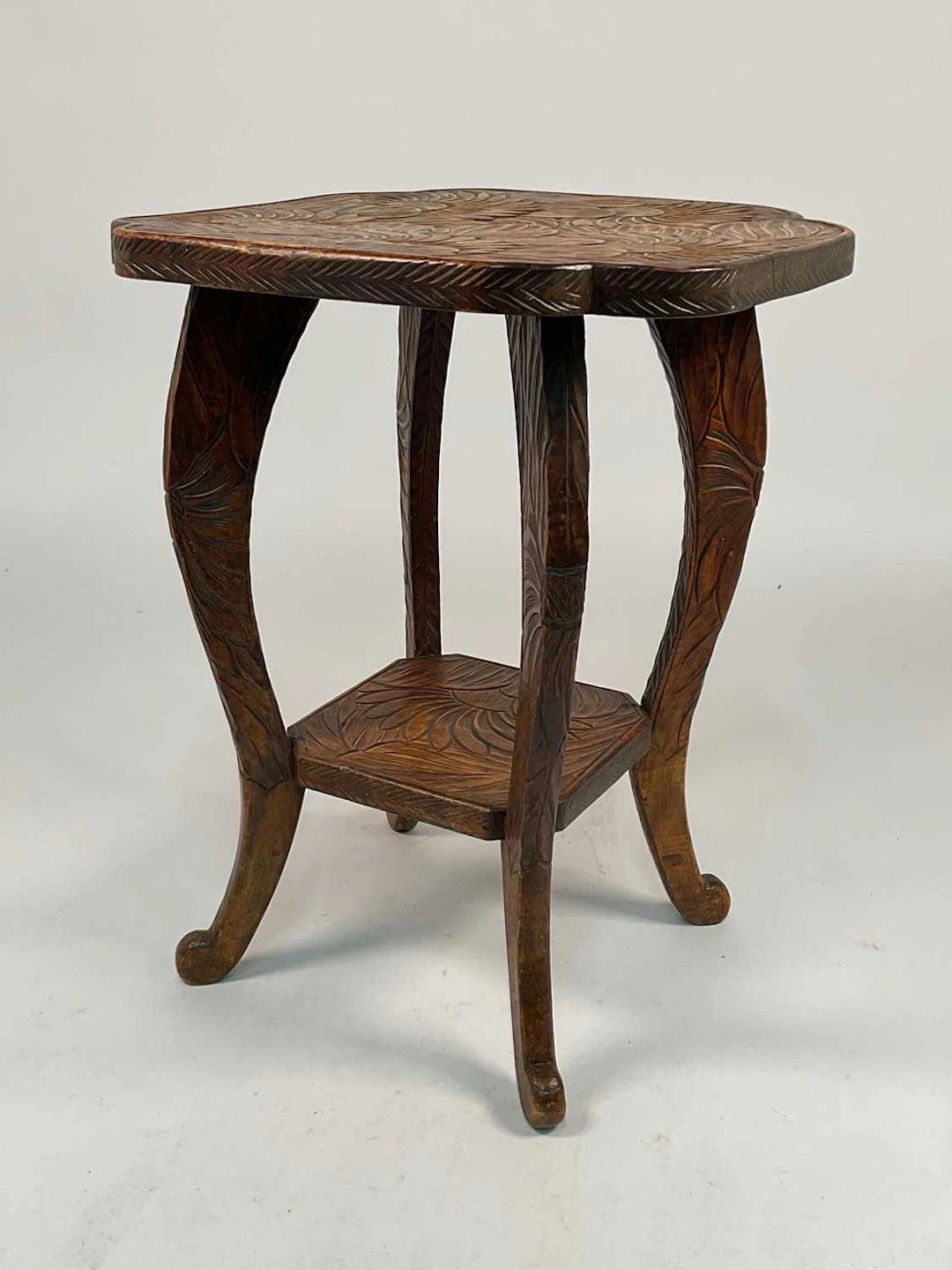 A hand carved oak two tier side table
