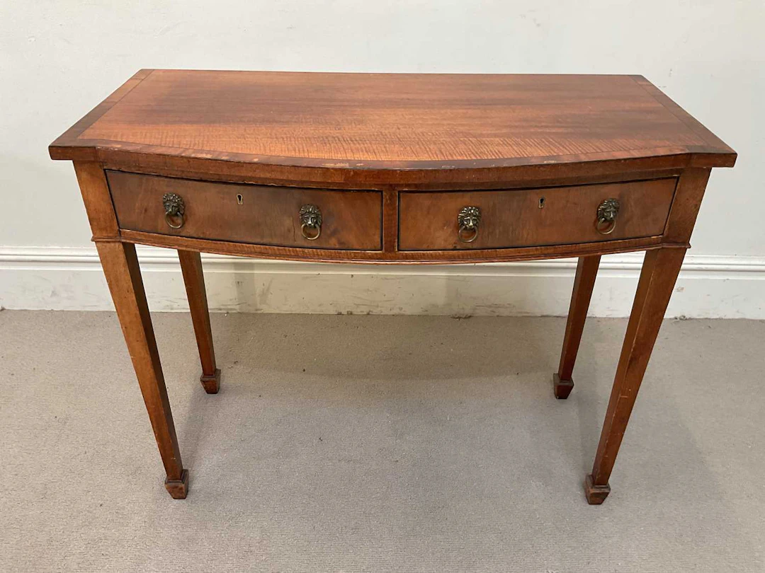 A reproduction mahogany bowfront two drawer cutlery/side table