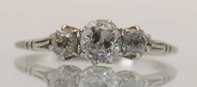 A white metal diamond three stone ring