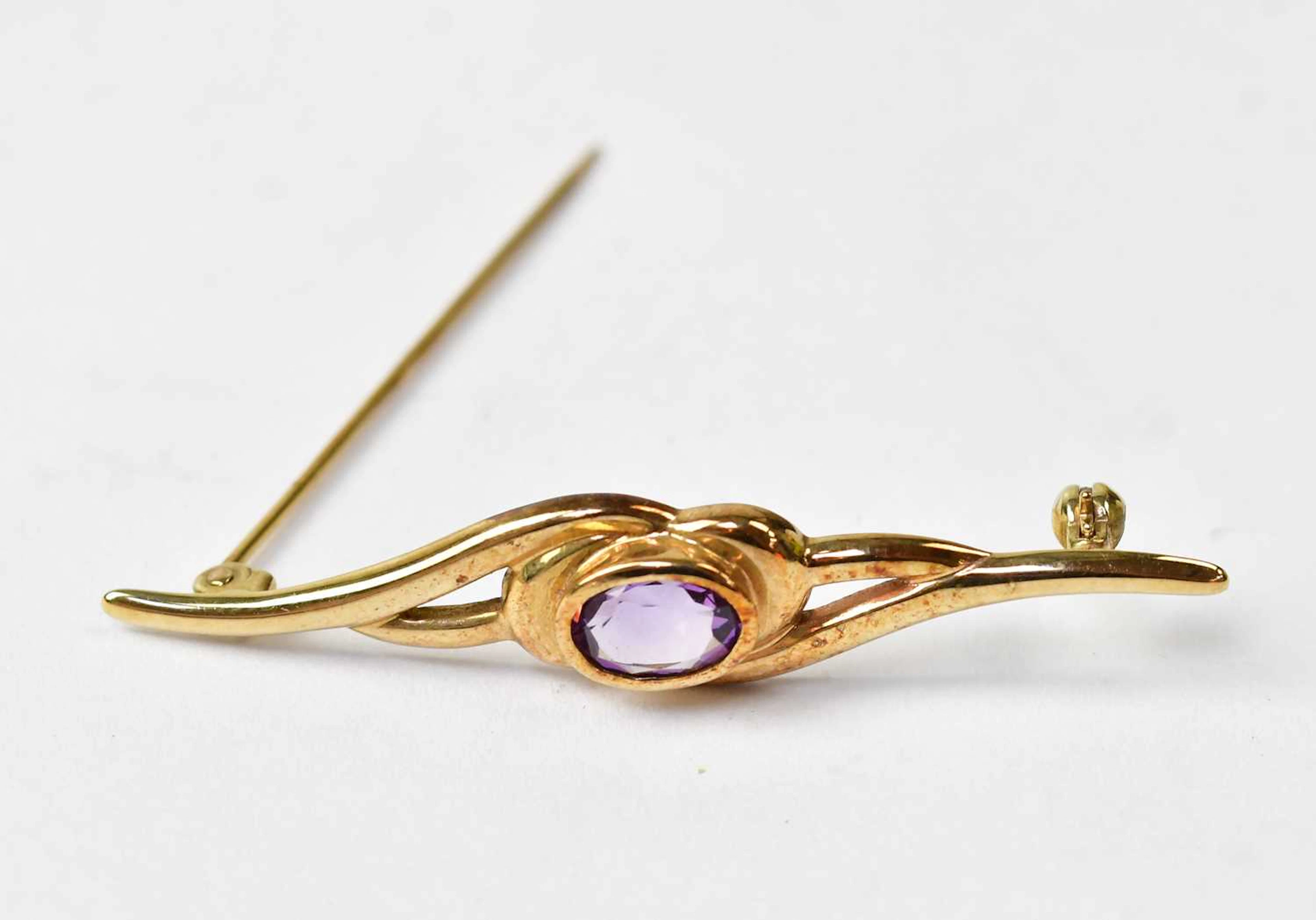 A 9ct yellow gold bar brooch set with a central oval amethyst
