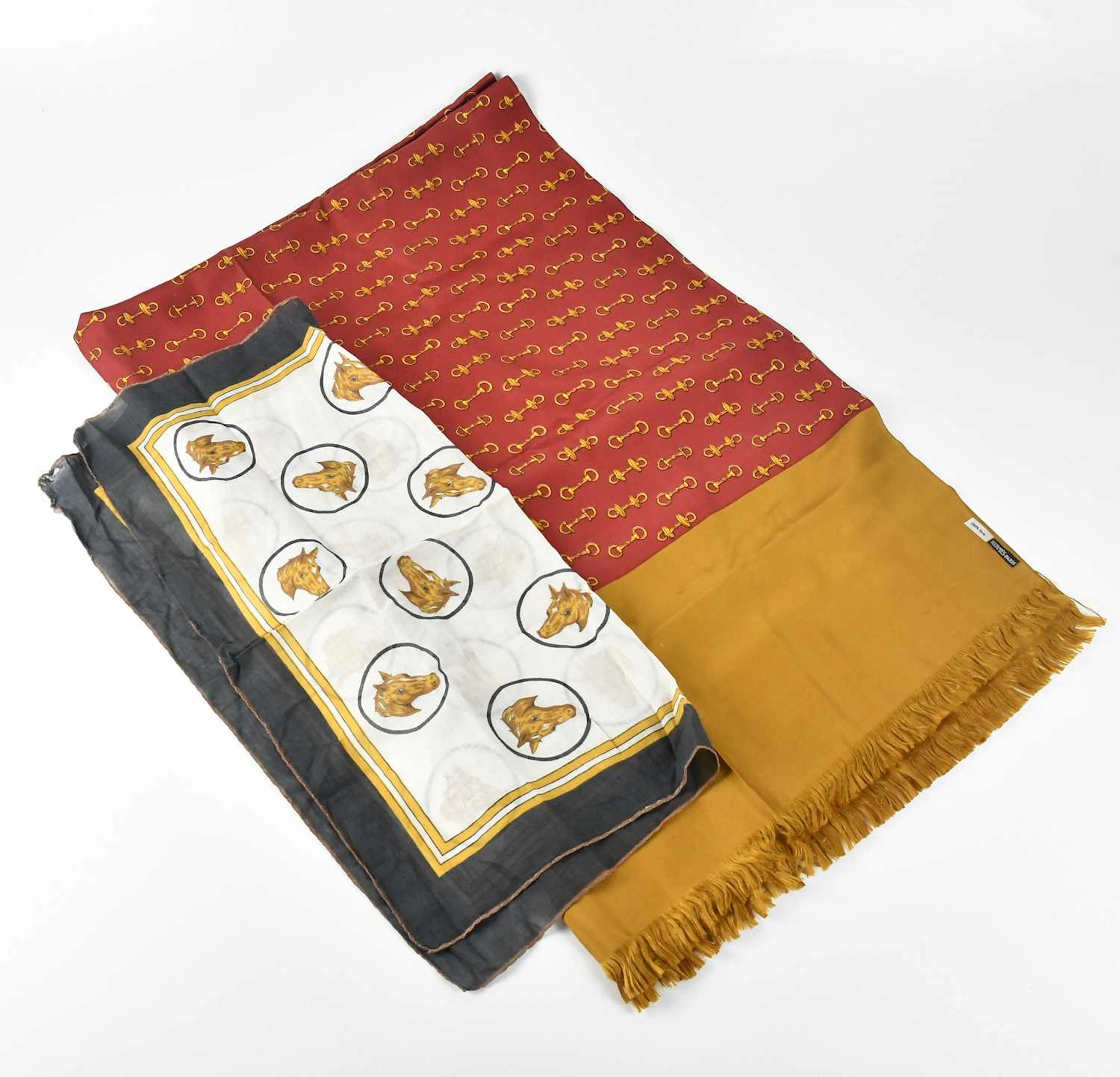 HERMÈS; a 100% silk fringed scarf depicting horse bit in gold and burgundy red