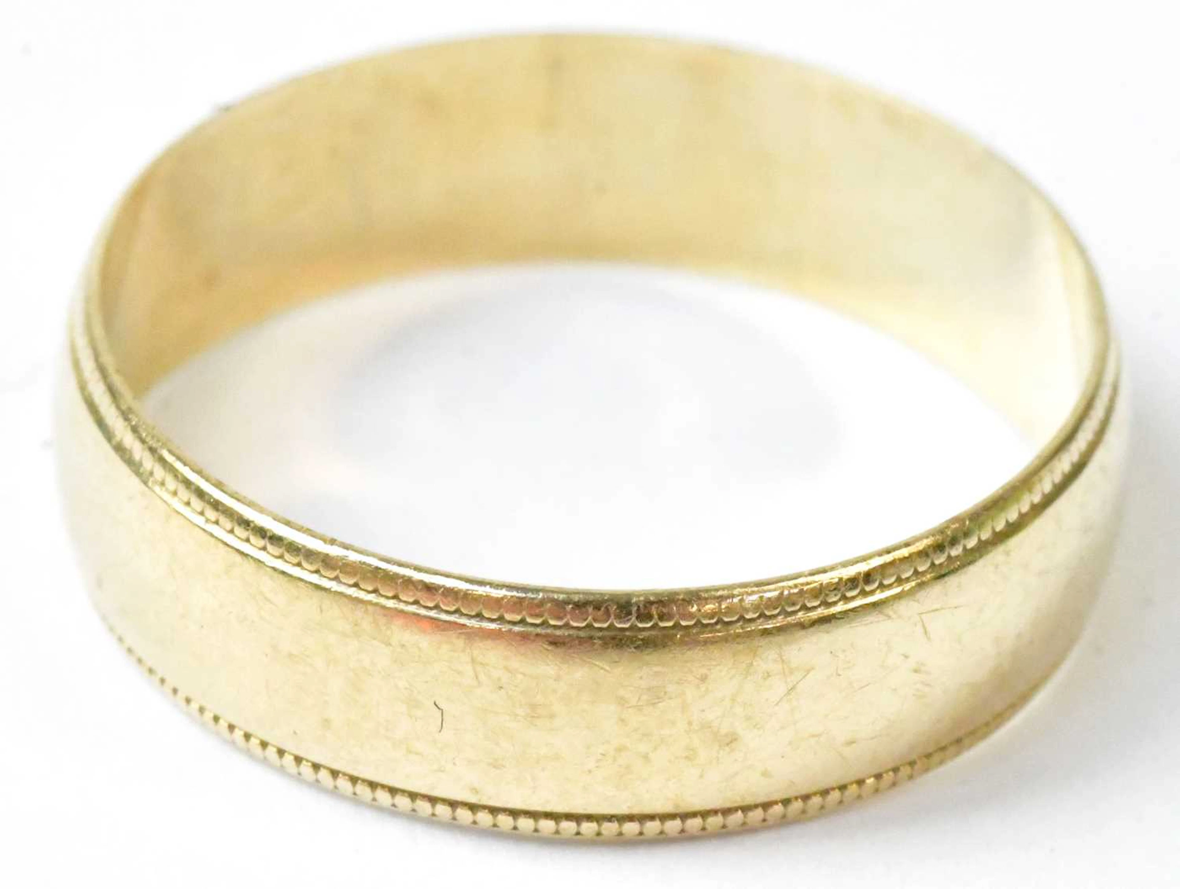 A 9ct yellow gold wedding band with beaded edges