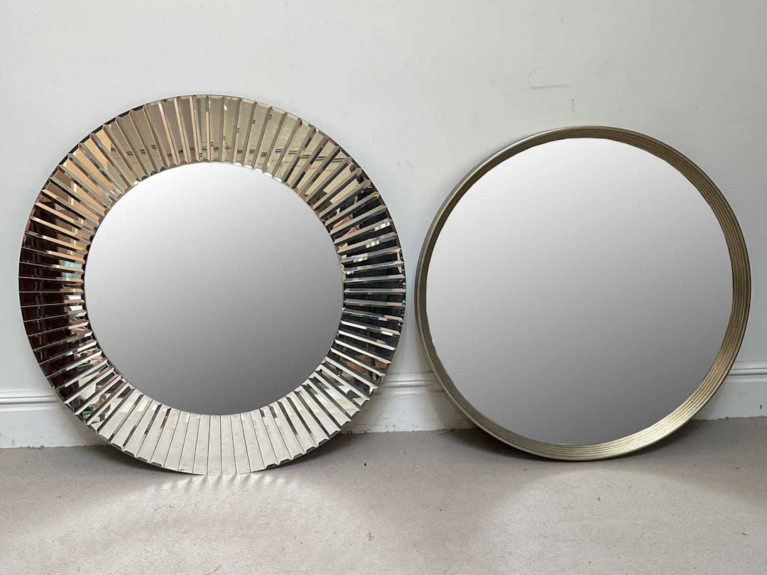 A large contemporary circular glass wall mirror with bevelled sections