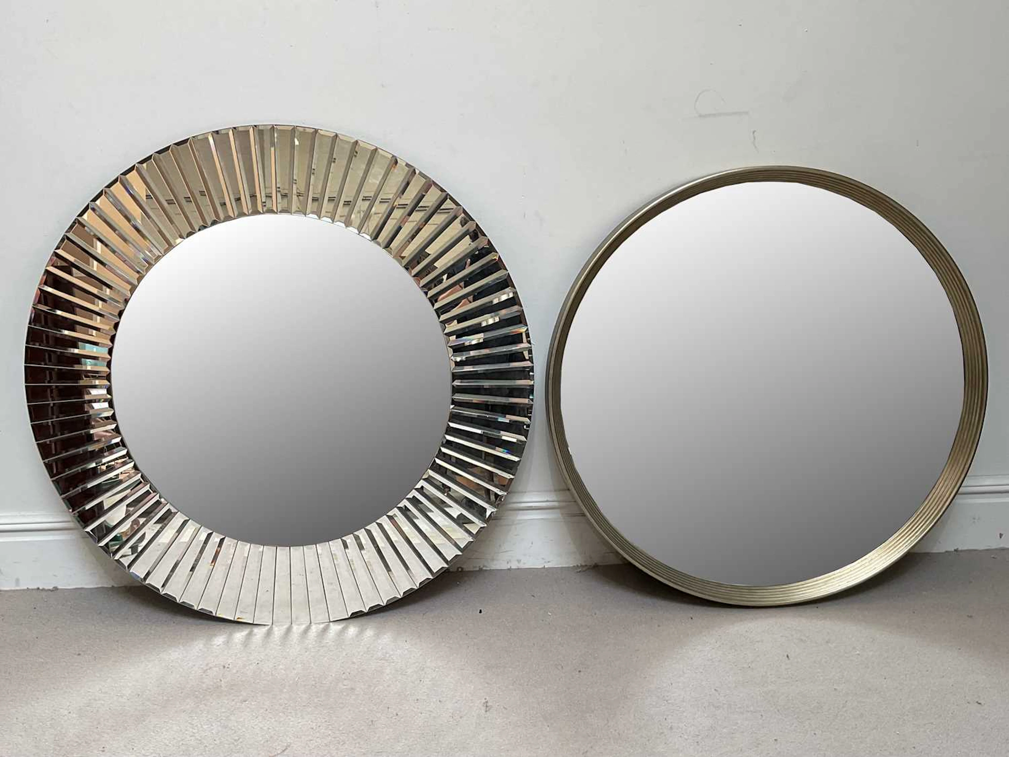 A large contemporary circular glass wall mirror with bevelled sections