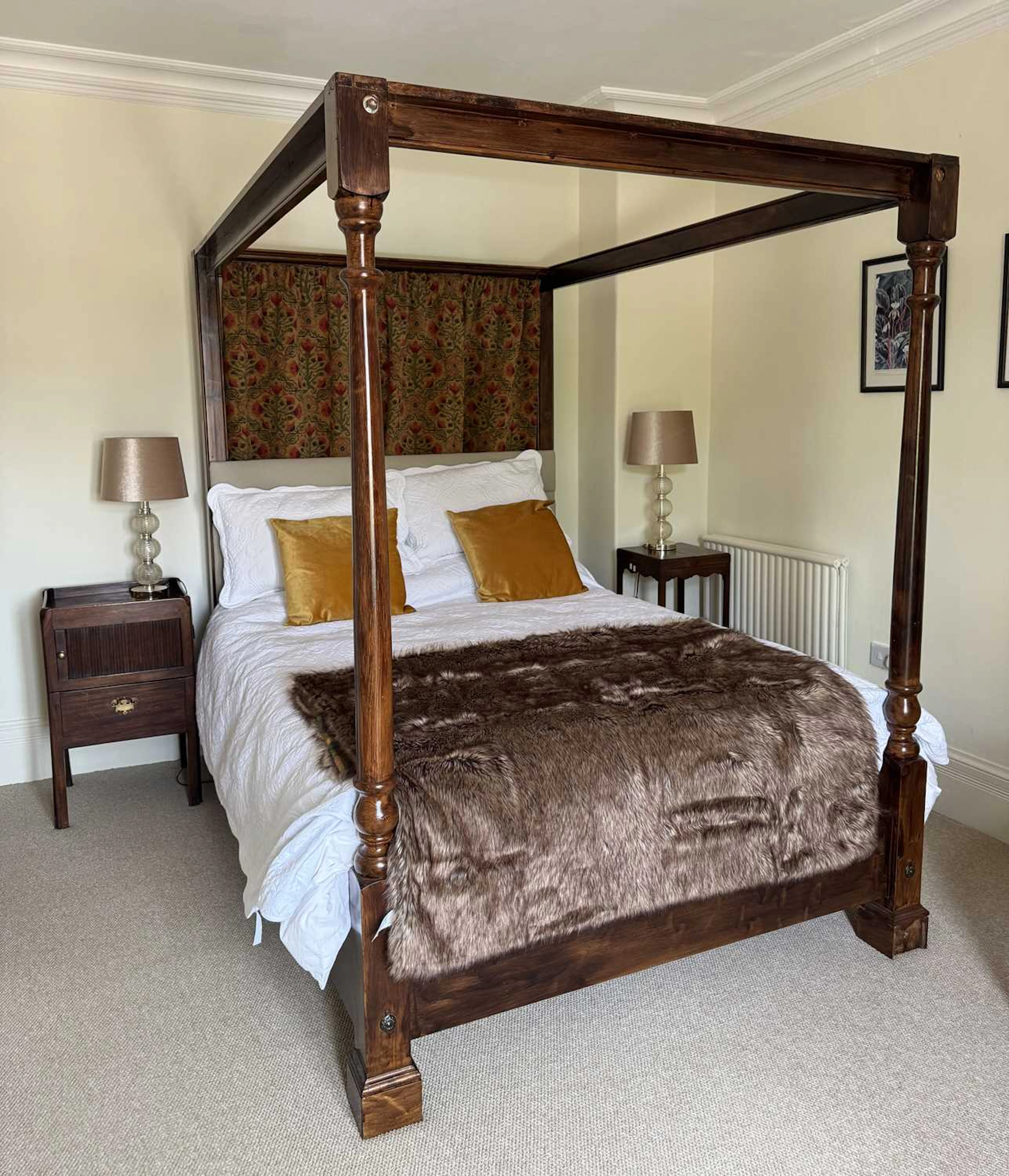 A modern stained pine four poster bed