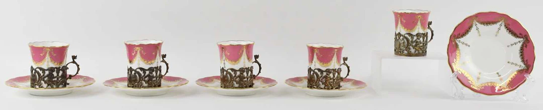 COALPORT; a set of five pink ground gilt heightened coffee cans and saucers