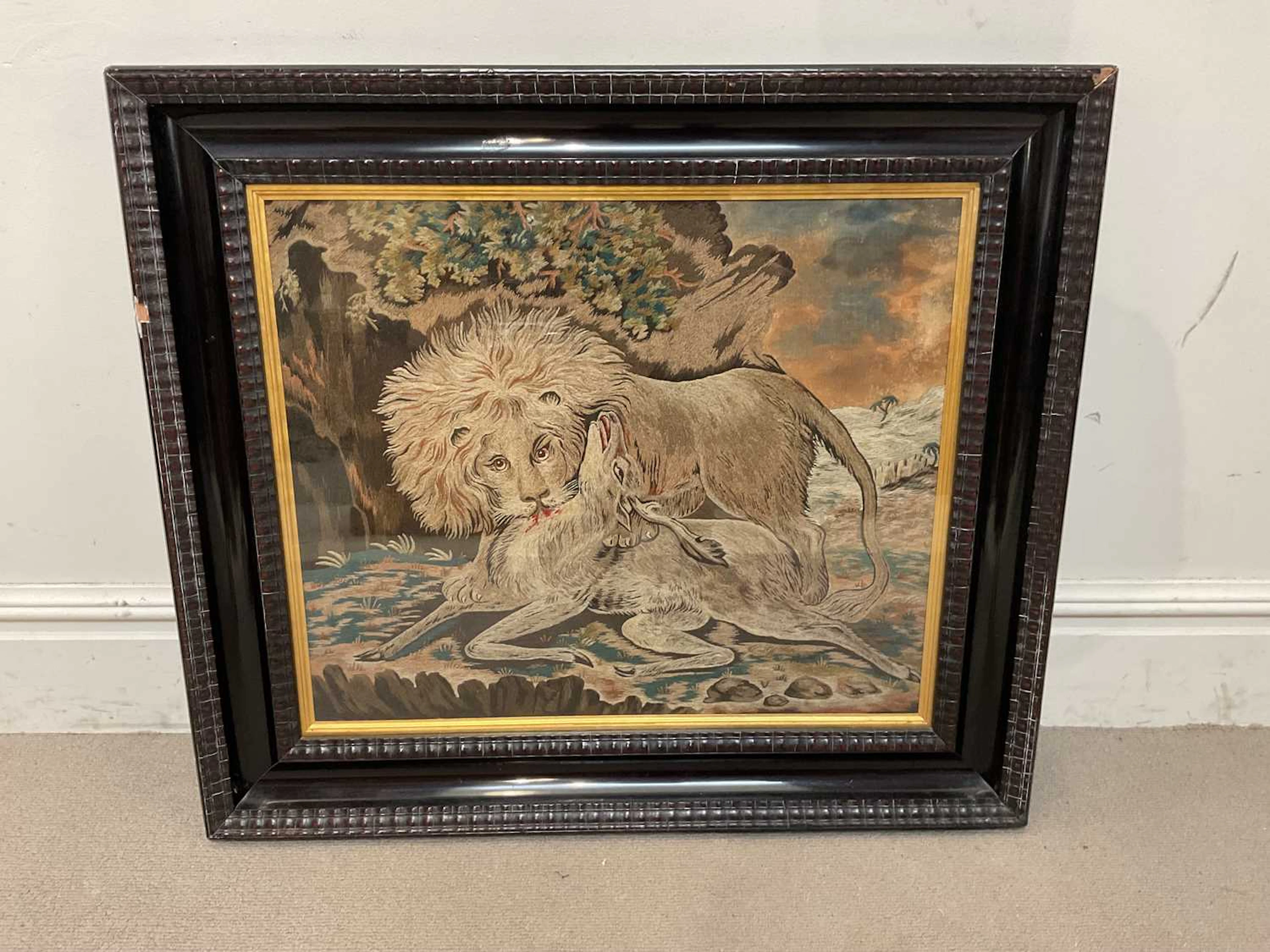 An early 19th century woolwork picture of a lion and a stag in a landscape