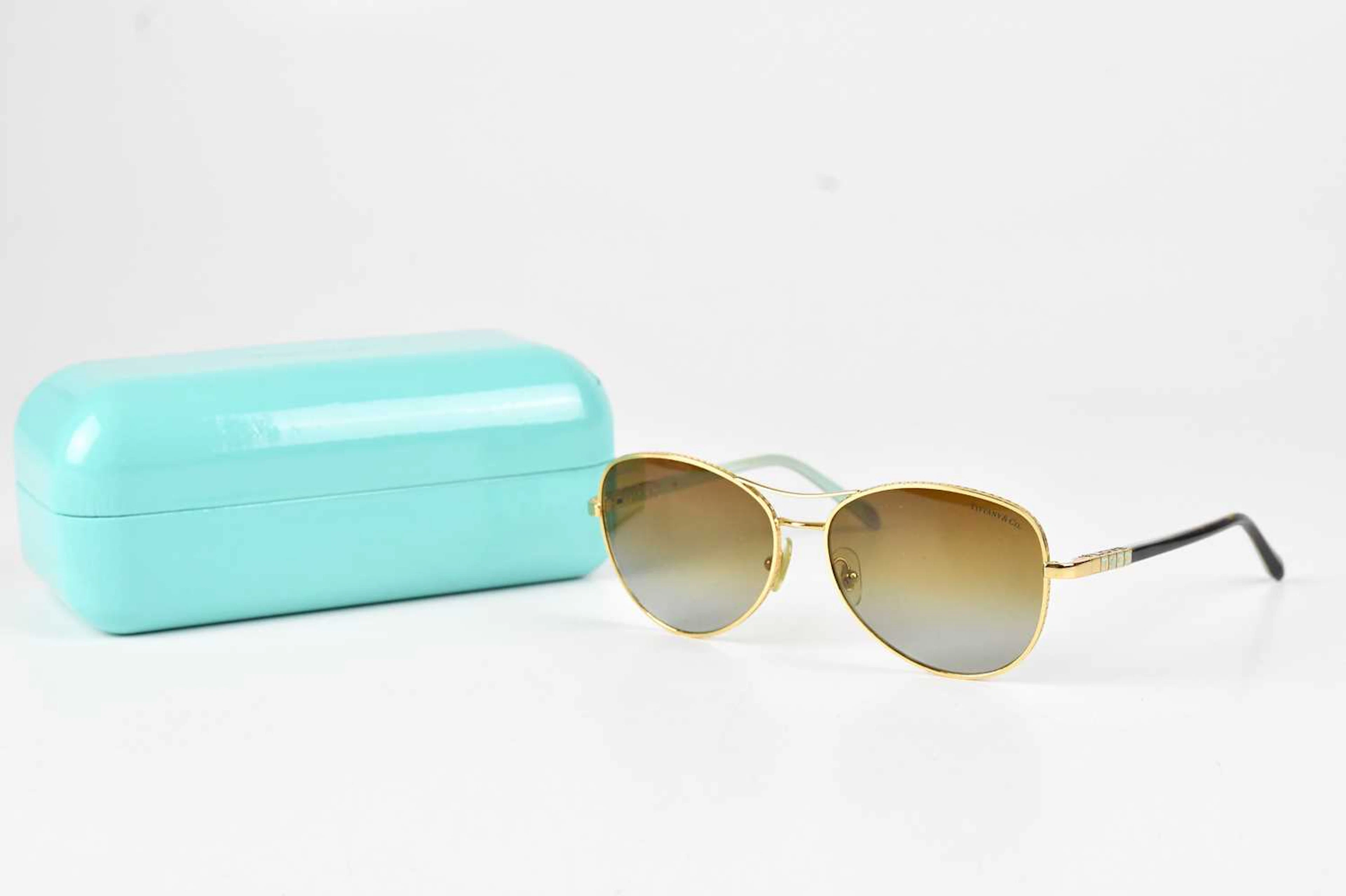 TIFFANY & CO; a pair of gold tone rimmed polarised sunglasses