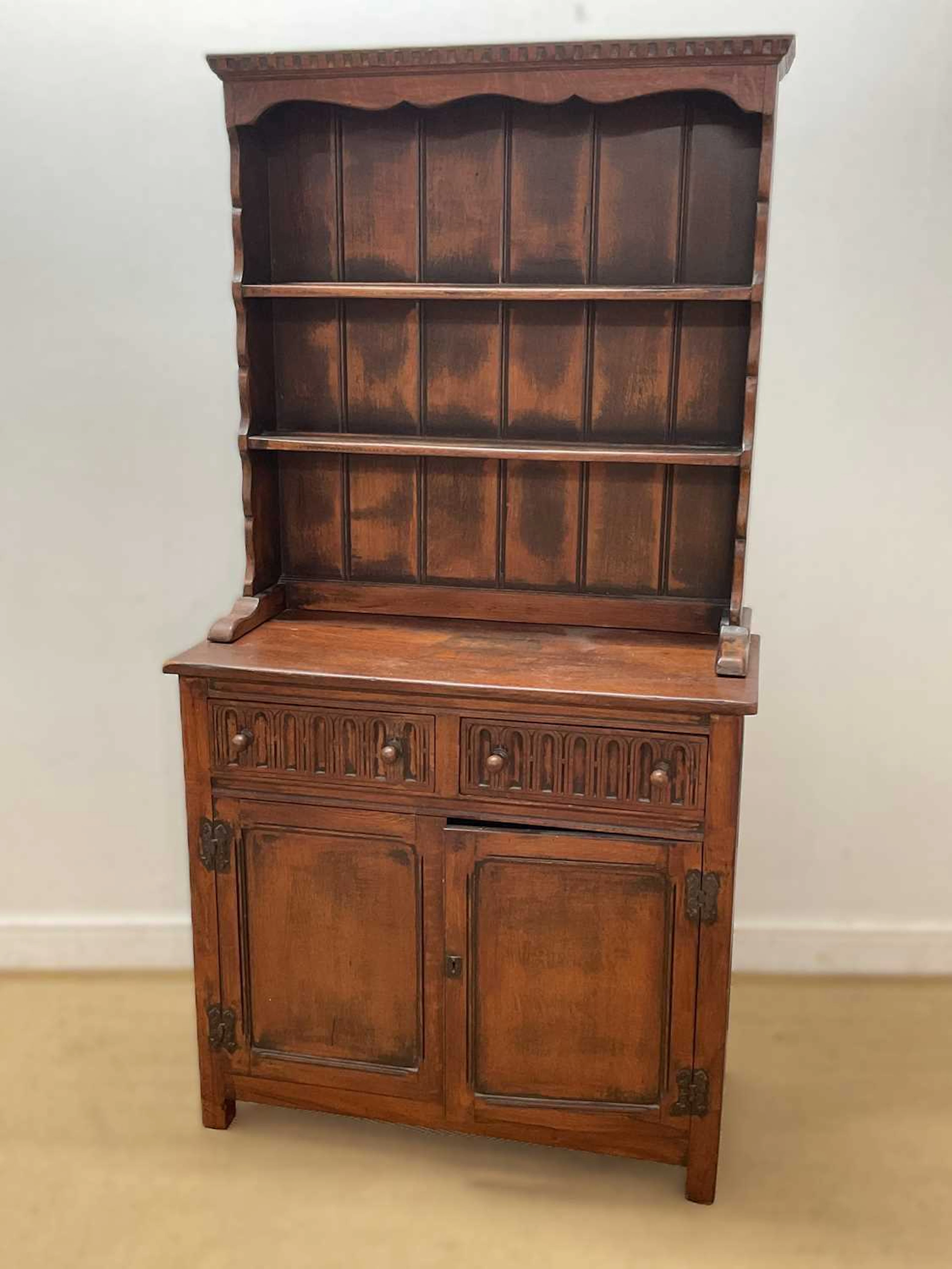 An oak kitchen dressser with two tier open plate rack and two door cupboard base