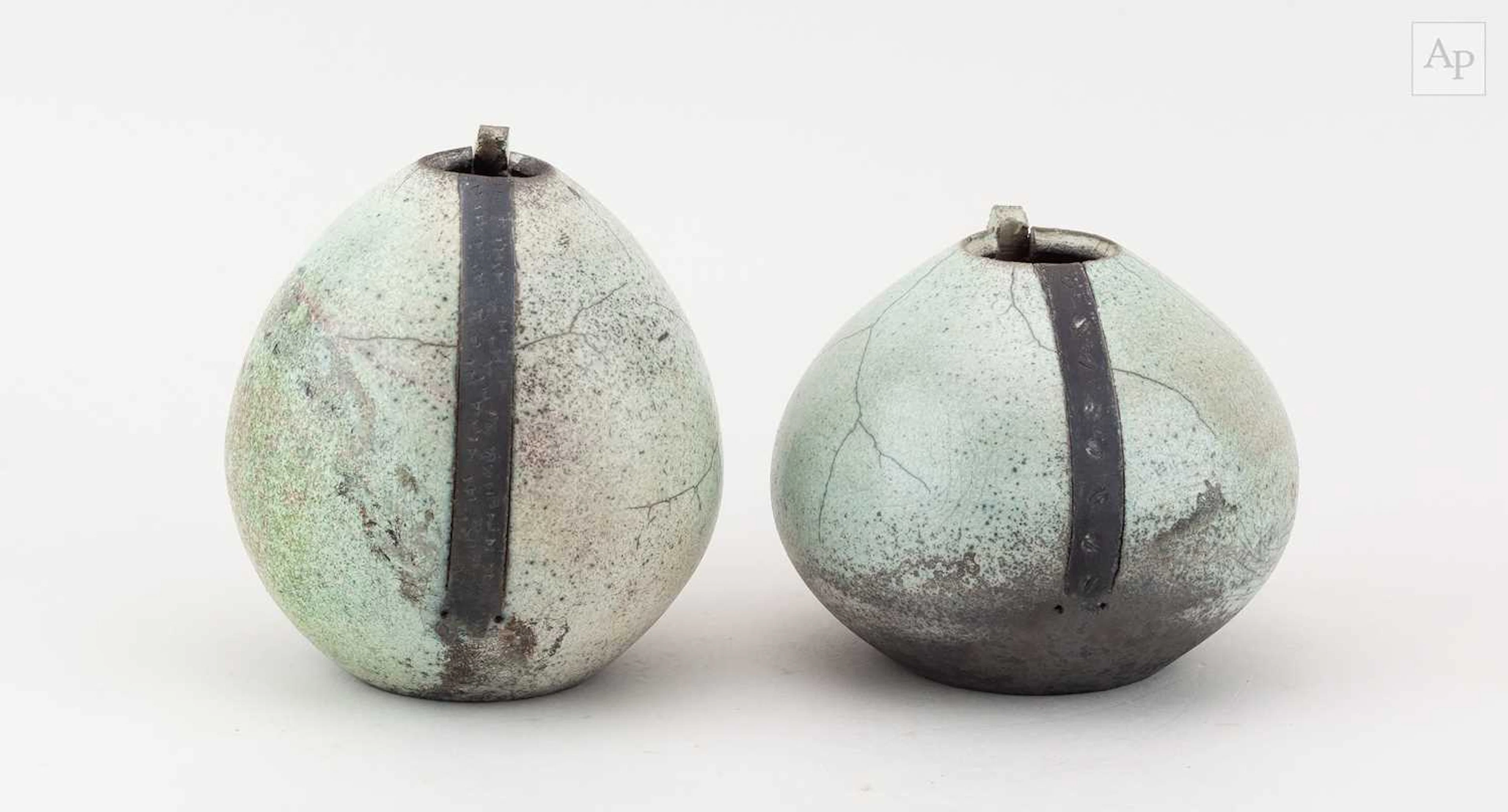 Two raku vessels with cut rims covered in speckled pale green glaze