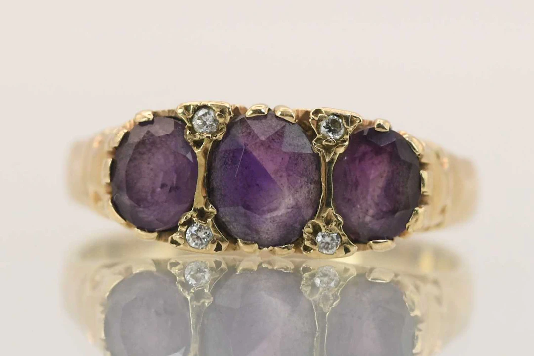 A 9ct yellow gold three stone set amethyst ring