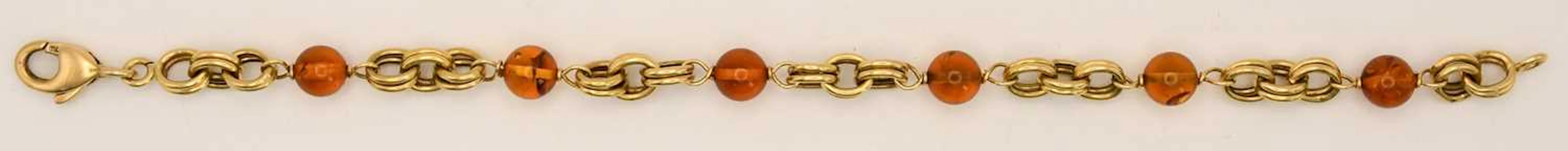 An 18ct yellow gold amber style bead and interlocking ring bracelet