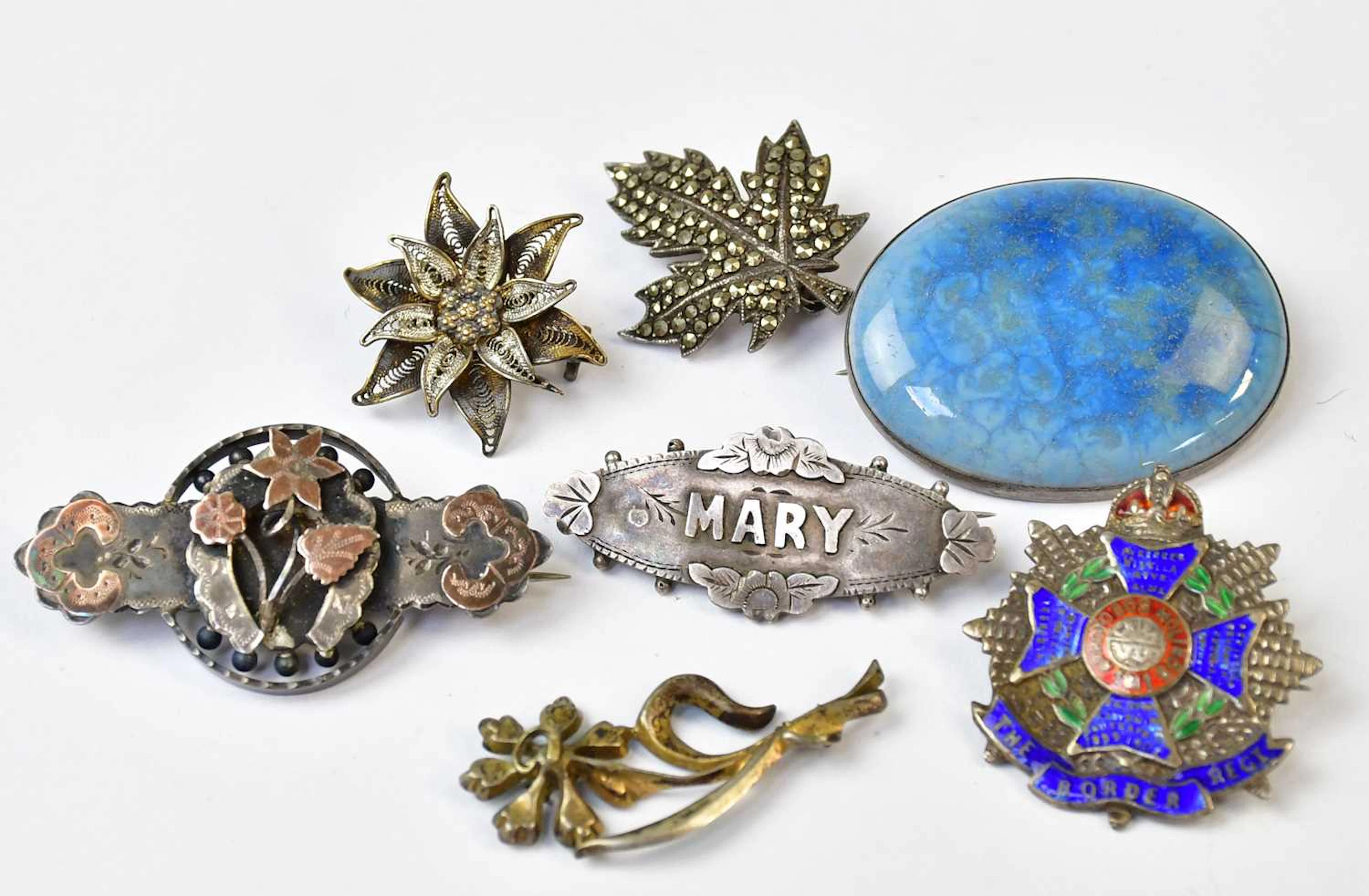 A Ruskin ceramic cabochon brooch in a white metal mount