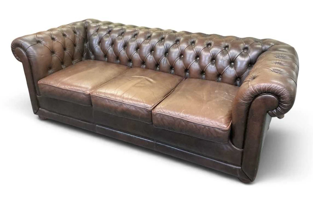 A modern brown button leather upholstered Chesterfield type three seater sofa