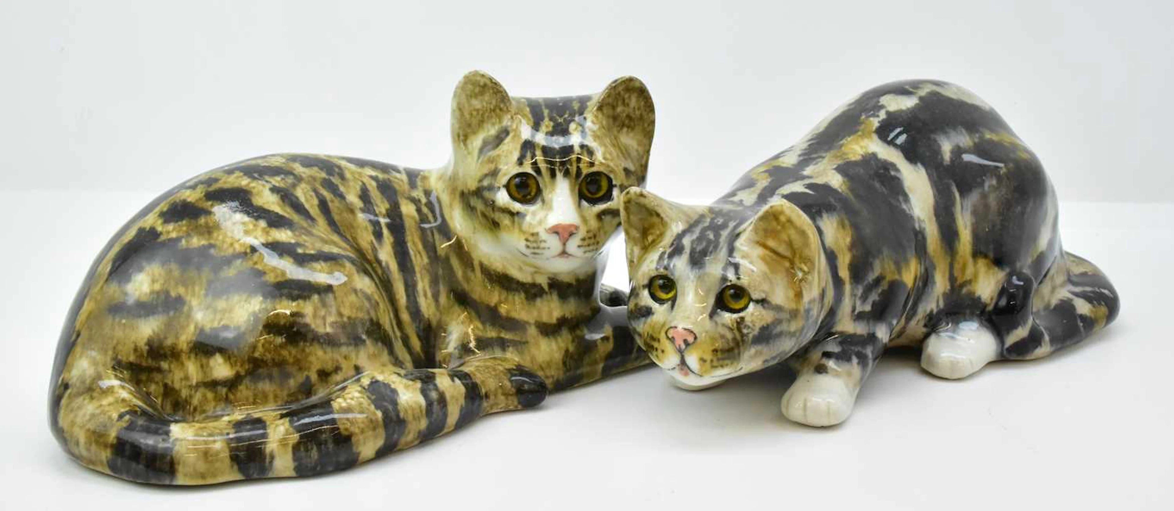 WINSTANLEY; two large pottery figures of tabby cats with glass eyes